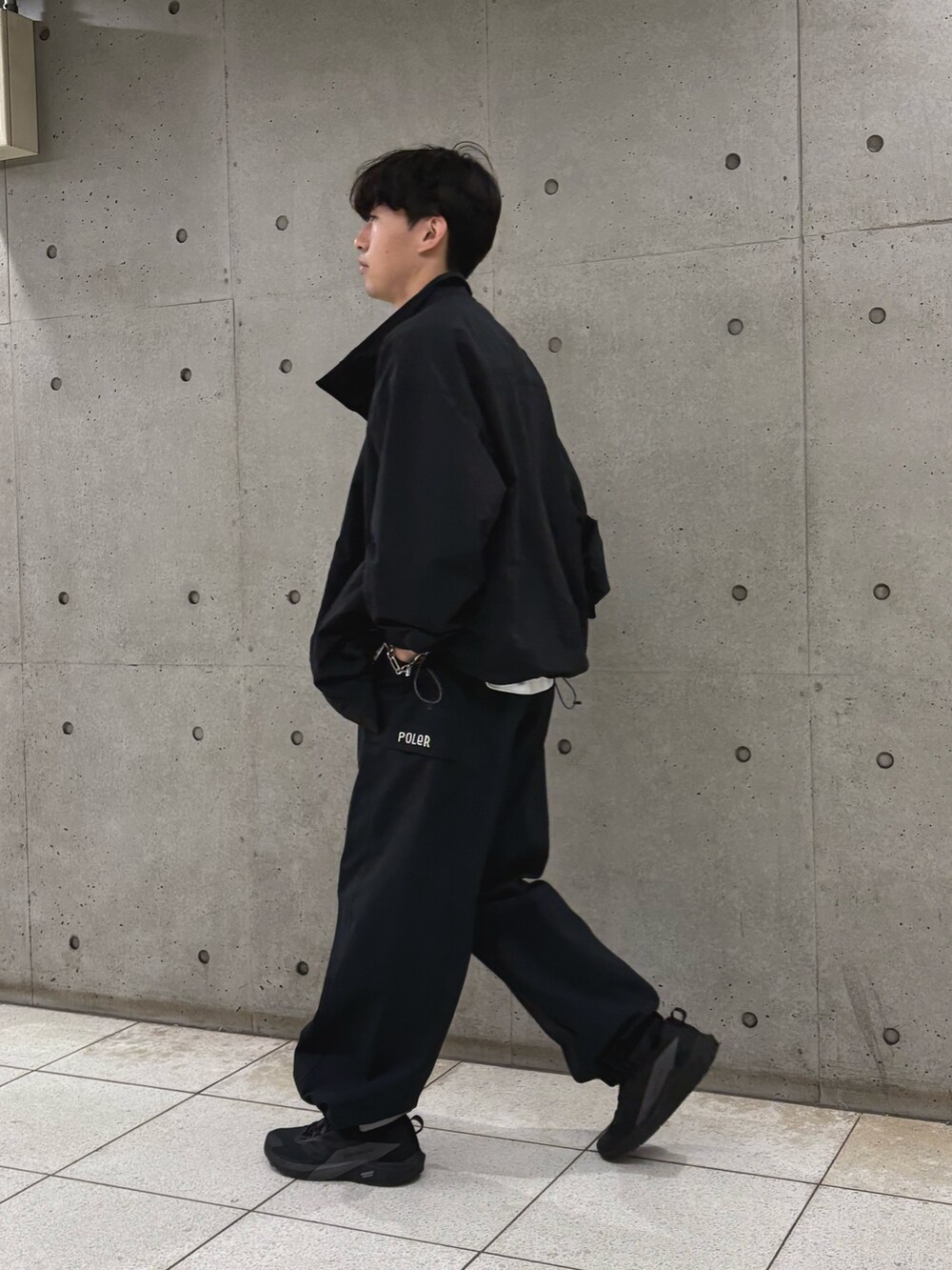 ブラック系のナイロンジャケット、ホワイト系のTシャツ/カットソーを着用したメンズの夏コーディネートの2枚目の写真