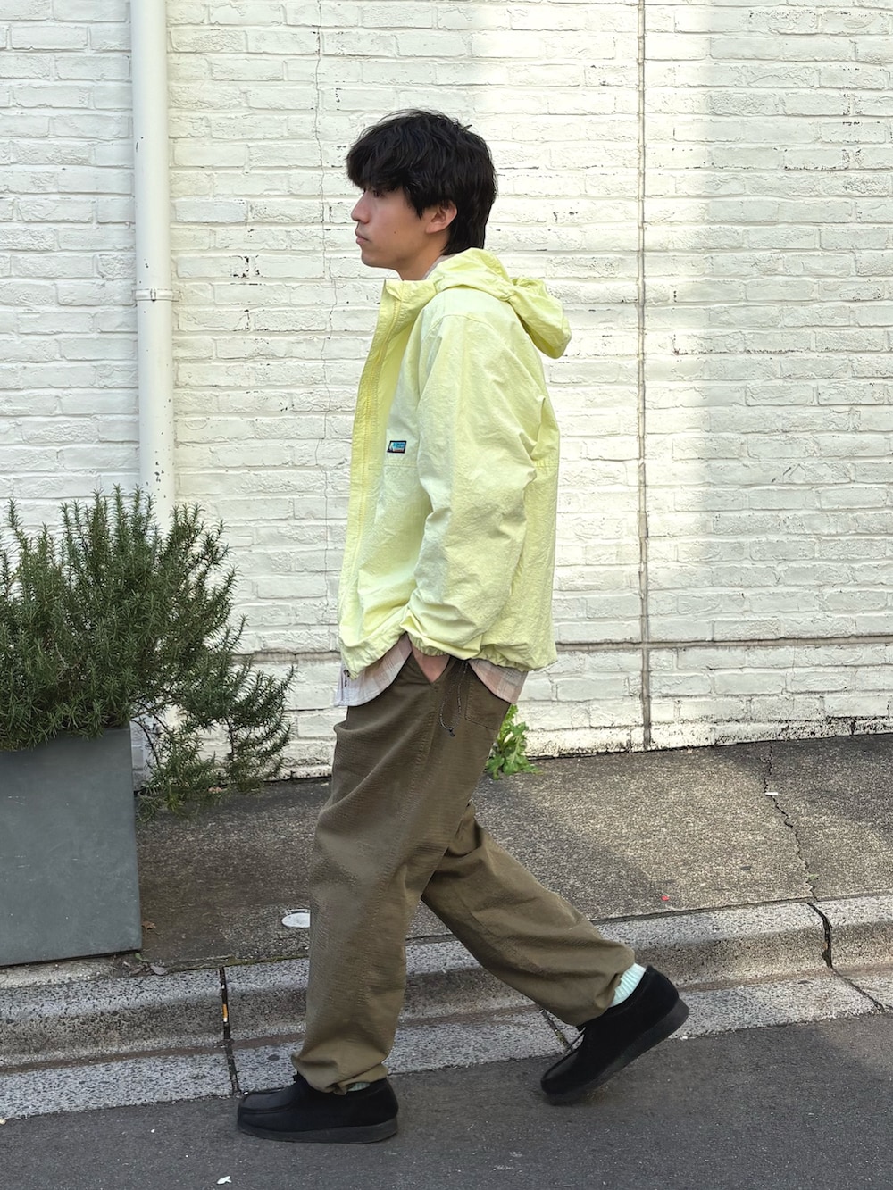 イエロー系のマウンテンパーカー、ピンク系のシャツ/ブラウス、グリーン系のその他パンツを着用したメンズの春コーディネートの2枚目の写真