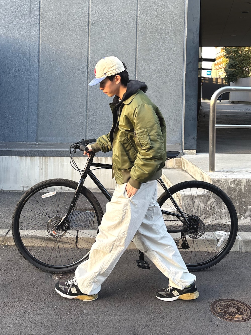 ブラック系のパーカー、グリーン系のMA-1を着用したメンズの冬コーディネートの2枚目の写真