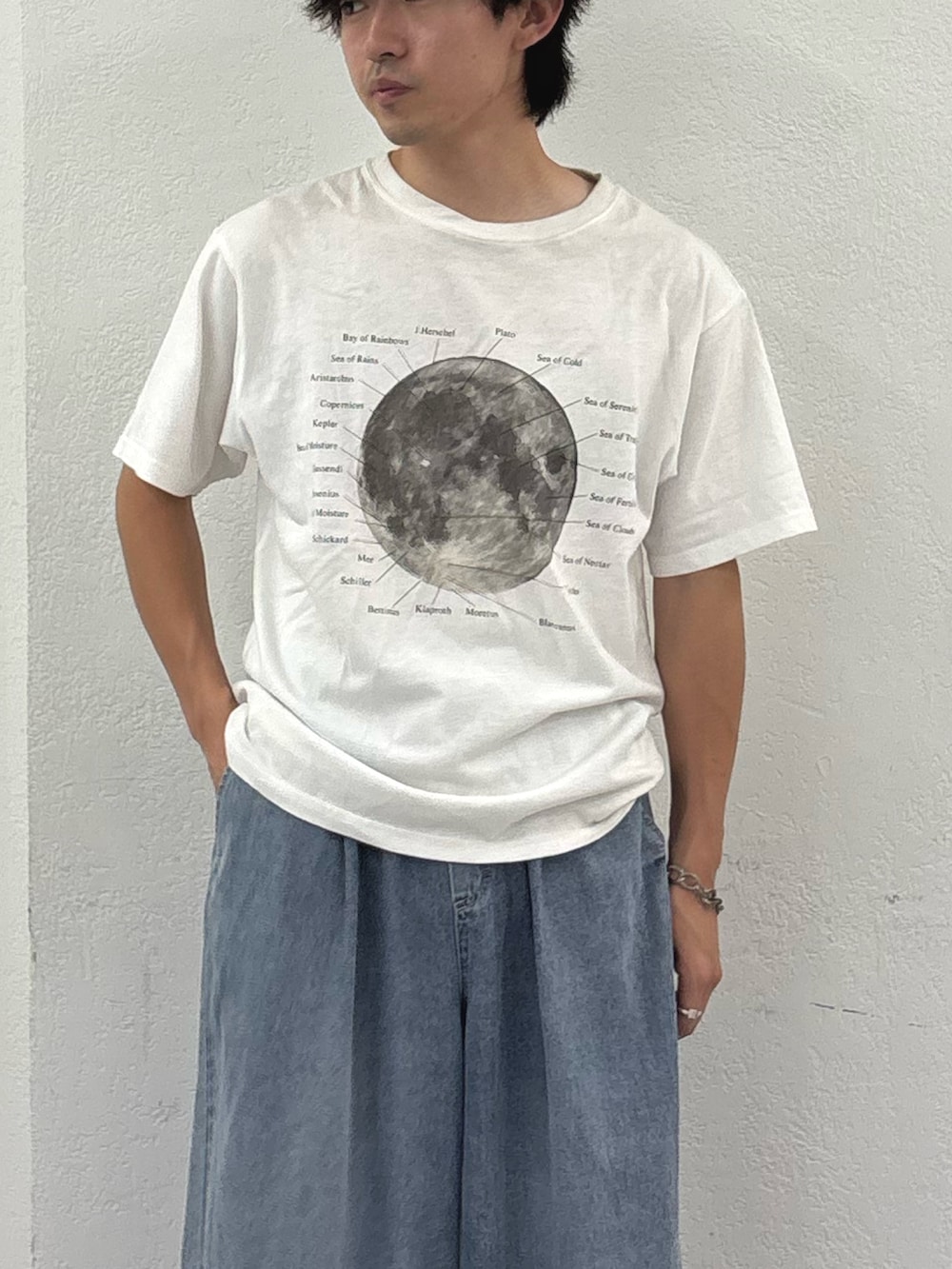 ブラック系のベスト、ホワイト系のTシャツ/カットソー、ブルー系のデニムパンツを着用したメンズの夏コーディネートの3枚目の写真