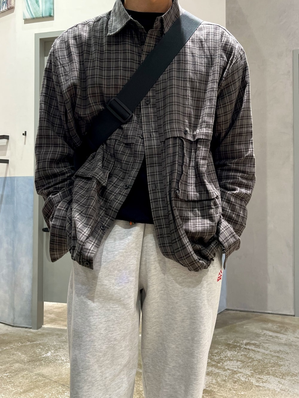 グレー系のスニーカー、グレー系のスウェットパンツ、ブラック系のニット/セーターを着用したメンズの冬コーディネートの3枚目の写真