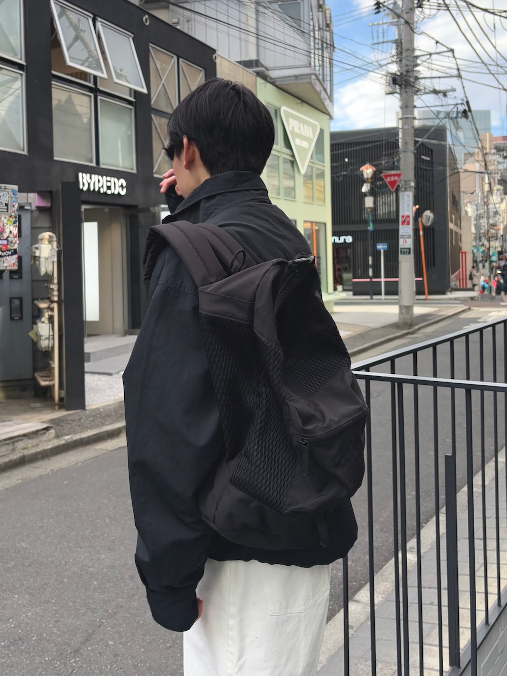 ブラック系のナイロンジャケット、ホワイト系のパンツ、ブラック系のバックパック/リュックを着用したメンズの冬コーディネートの3枚目の写真