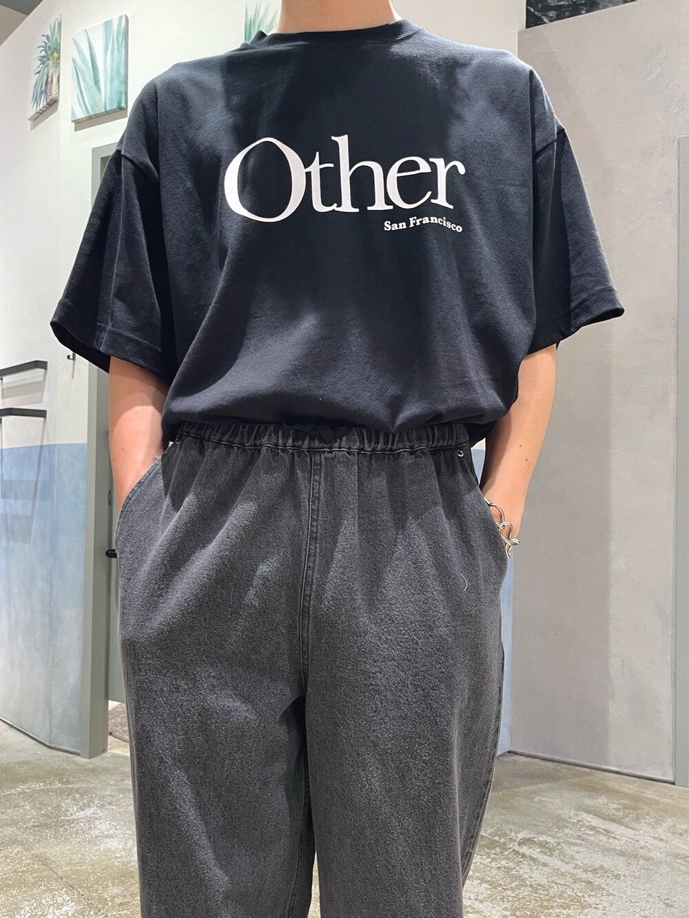 ブラック系のデニムパンツ、ブラック系のローファー、ブラック系のTシャツ/カットソーを着用したメンズの夏コーディネートの3枚目の写真