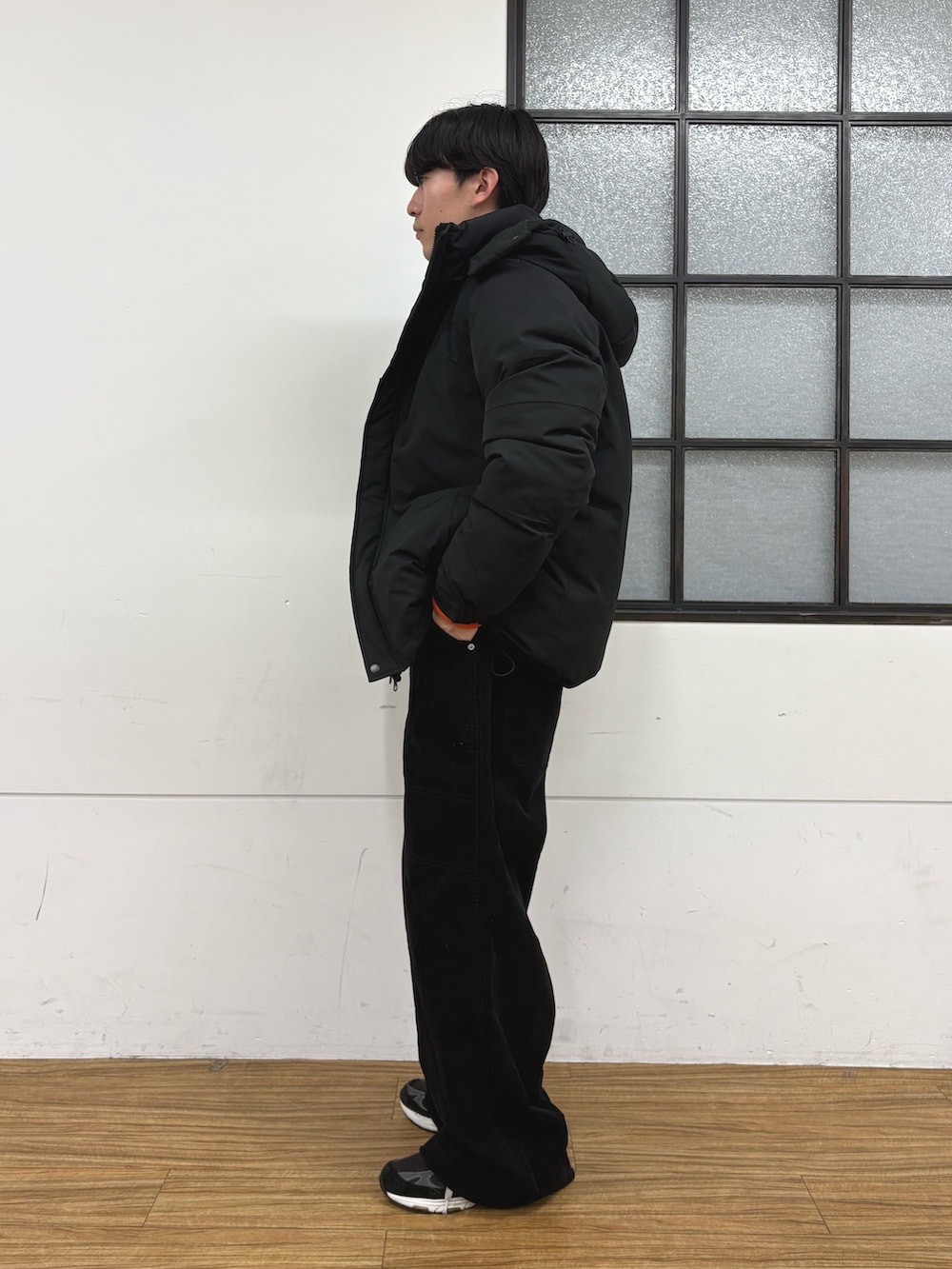 ブラック系のダウンジャケット/コート、グレー系のニット/セーター、ブラック系のその他パンツを着用したメンズの冬コーディネートの2枚目の写真