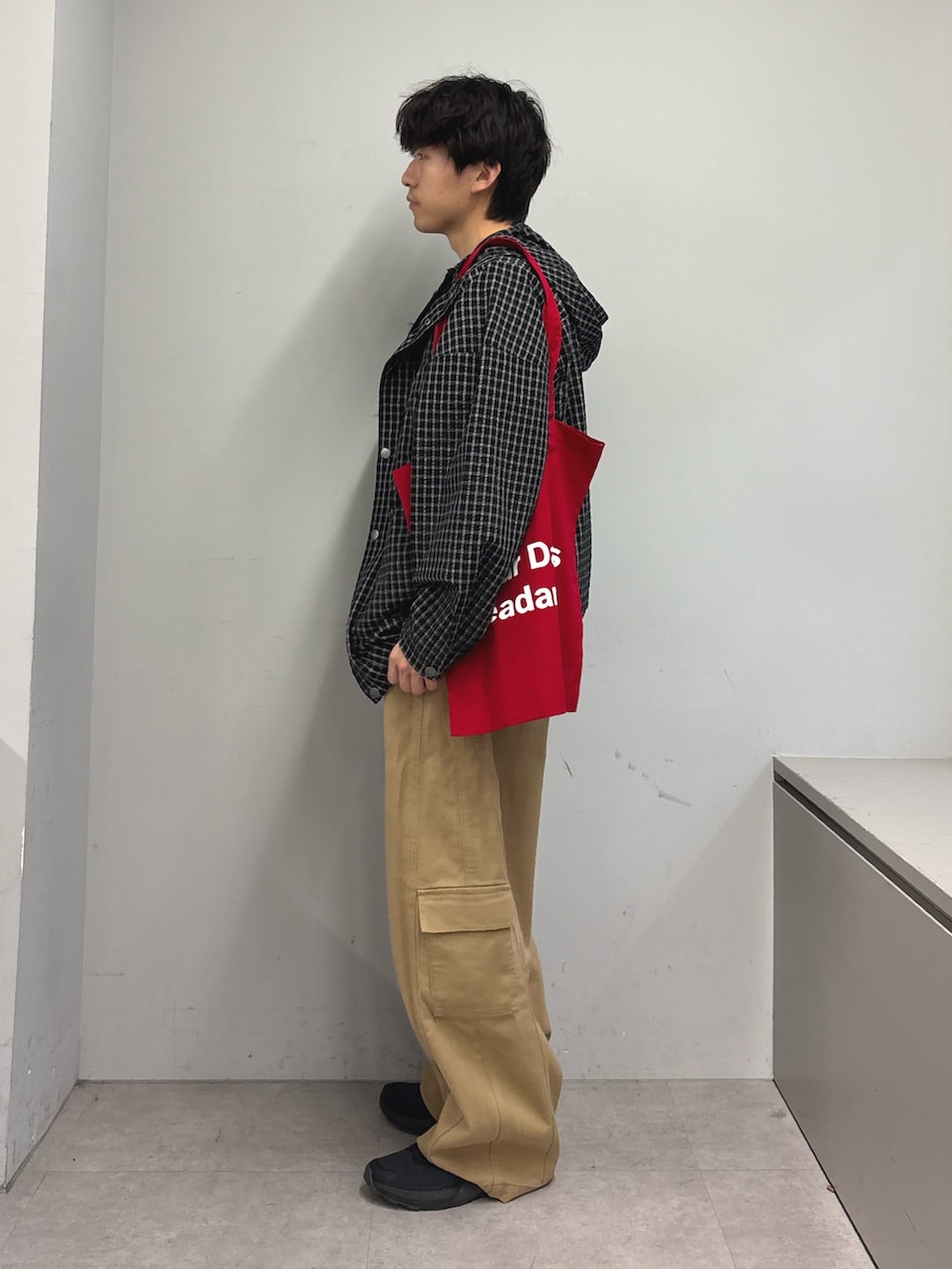 ブラック系のパーカー、ブラック系のTシャツ/カットソー、レッド系のトートバッグを着用したメンズの春コーディネートの2枚目の写真