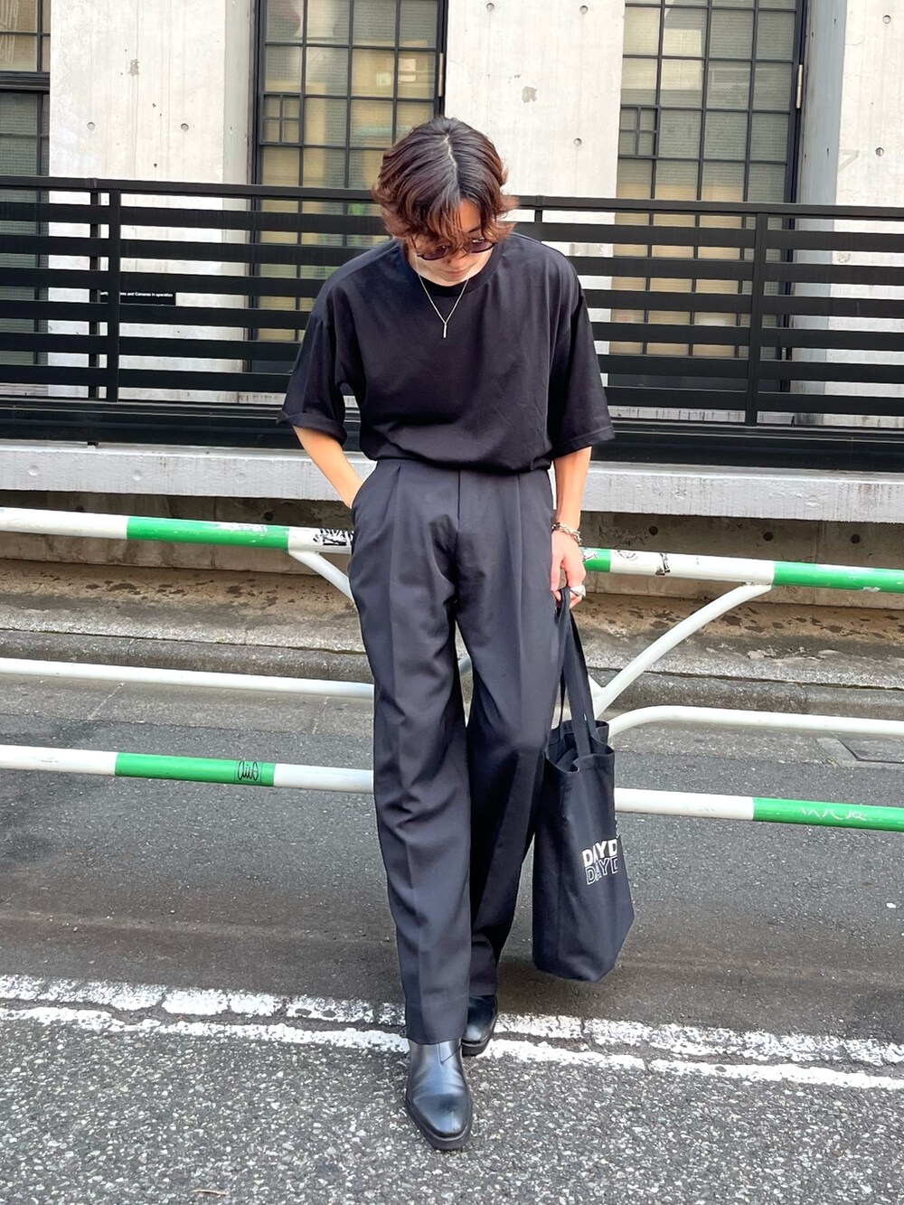 ブラック系のブーツ、ブラック系のトートバッグ、ブラック系のスラックスを着用したメンズの夏コーディネートの2枚目の写真