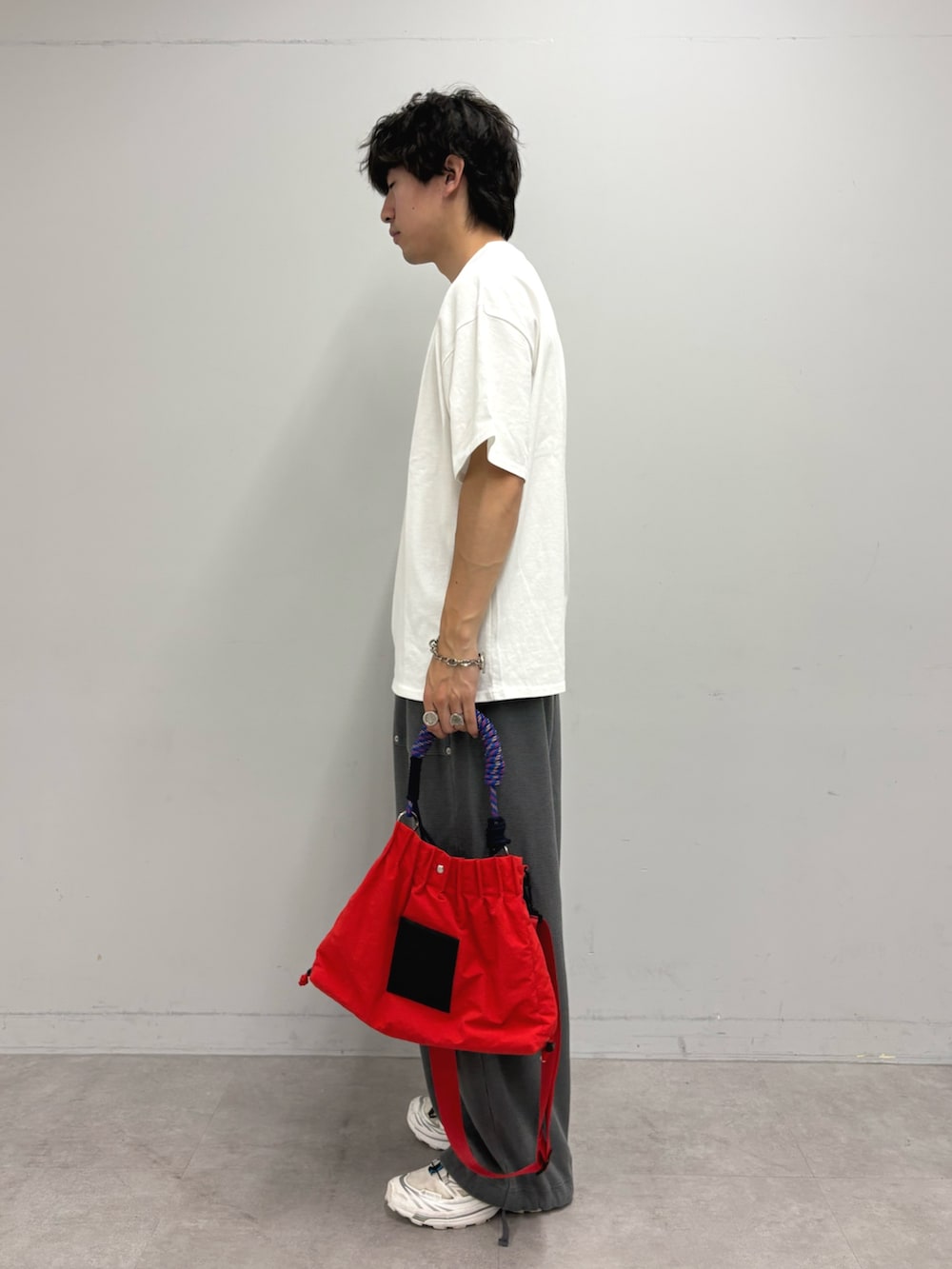 ホワイト系のTシャツ/カットソー、グレー系のスウェットパンツ、レッド系のトートバッグを着用したメンズの夏コーディネートの2枚目の写真