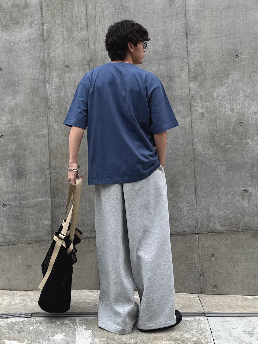 ブルー系のTシャツ/カットソー、ブラック系のトートバッグを着用したメンズの春コーディネートの2枚目の写真