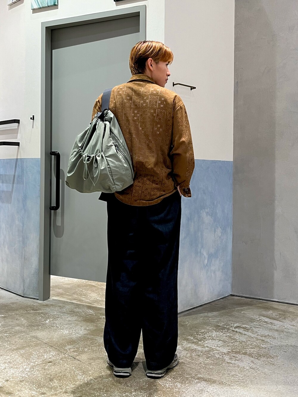 グレー系のスニーカー、ブルー系のデニムパンツ、ブラウン系のシャツ/ブラウスを着用したメンズの秋コーディネートの2枚目の写真