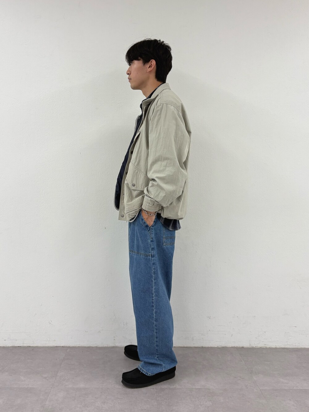 ベージュ系のナイロンジャケット、ブルー系のシャツ/ブラウス、ブルー系のデニムパンツを着用したメンズの秋コーディネートの2枚目の写真