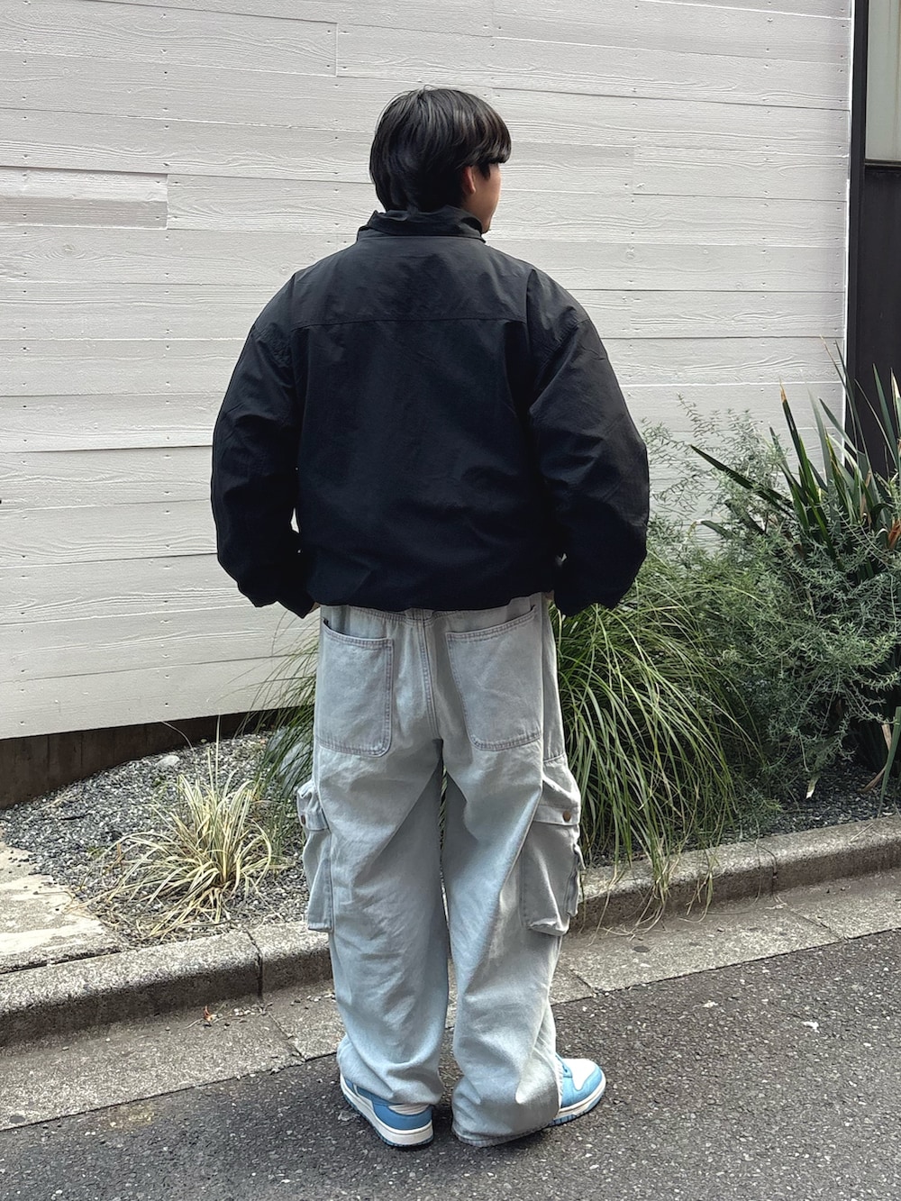 ブラック系のナイロンジャケット、ブルー系のデニムパンツを着用したメンズの冬コーディネートの3枚目の写真