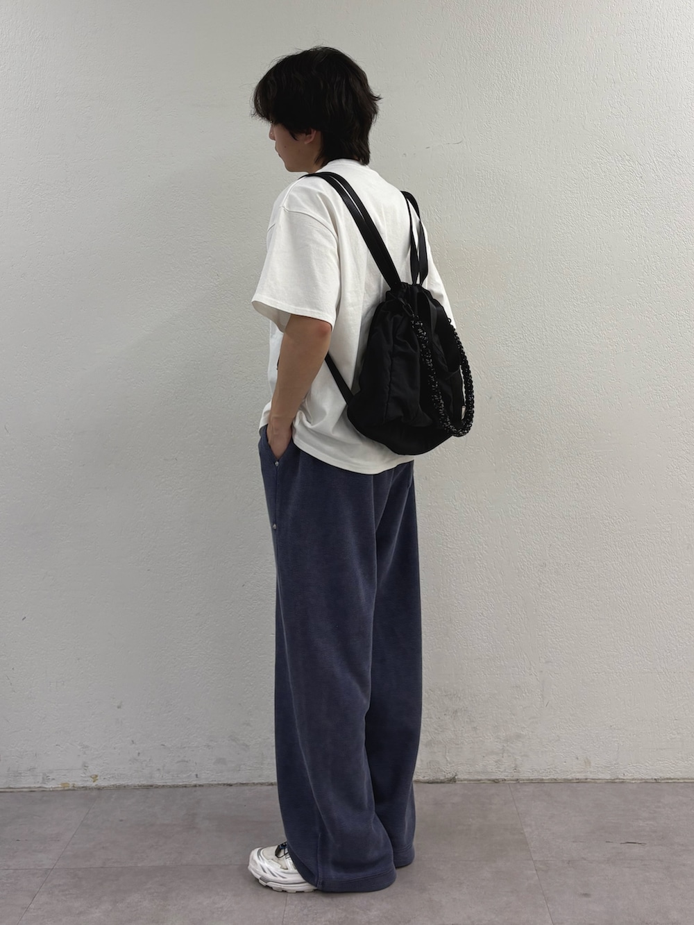 ホワイト系のTシャツ/カットソー、ブラック系のトートバッグ、ブルー系のスウェットパンツを着用したメンズの春コーディネートの2枚目の写真