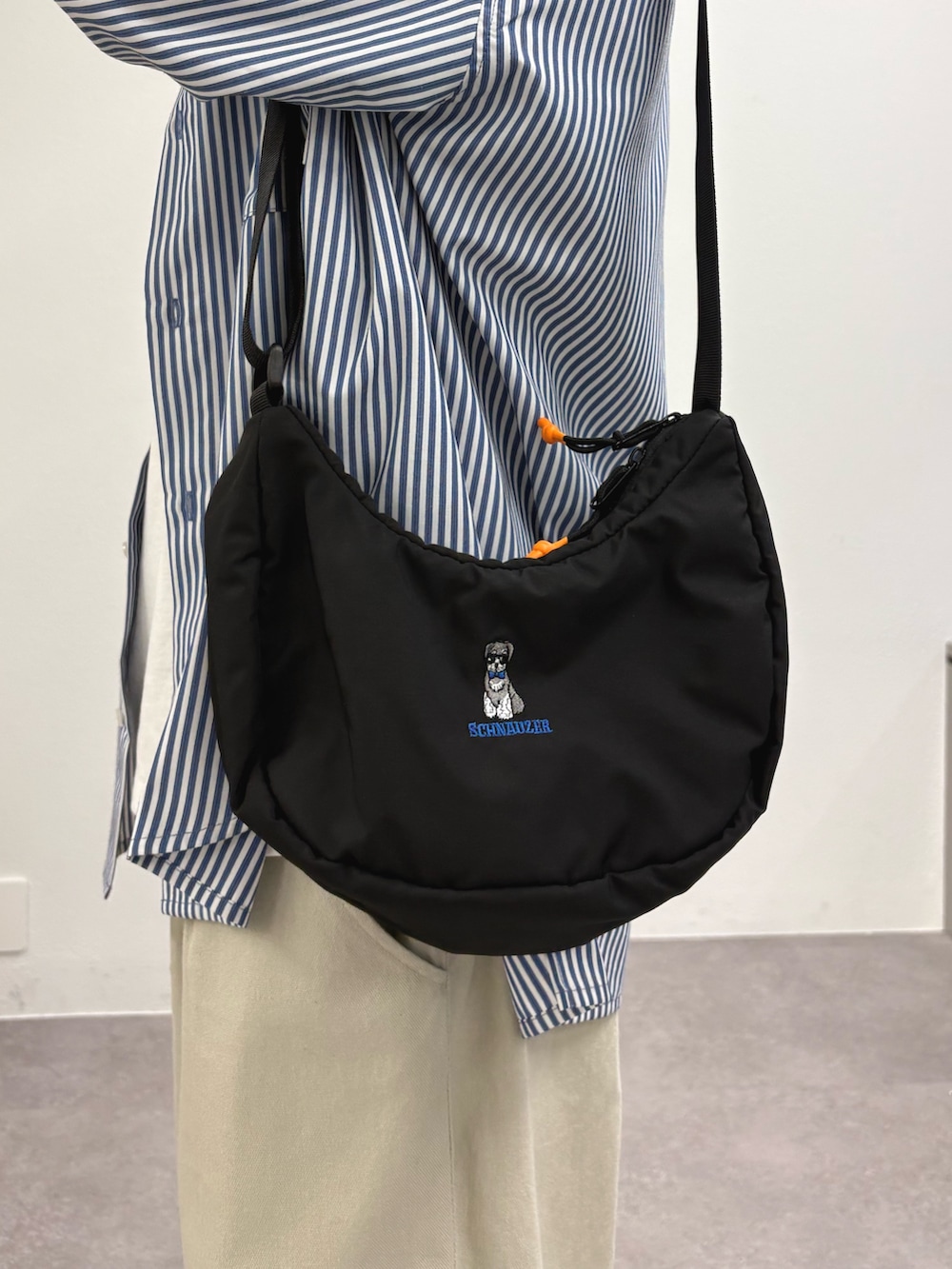 ブルー系のシャツ/ブラウス、ホワイト系のTシャツ/カットソー、ブラック系のショルダーバッグを着用したメンズの春コーディネートの2枚目の写真