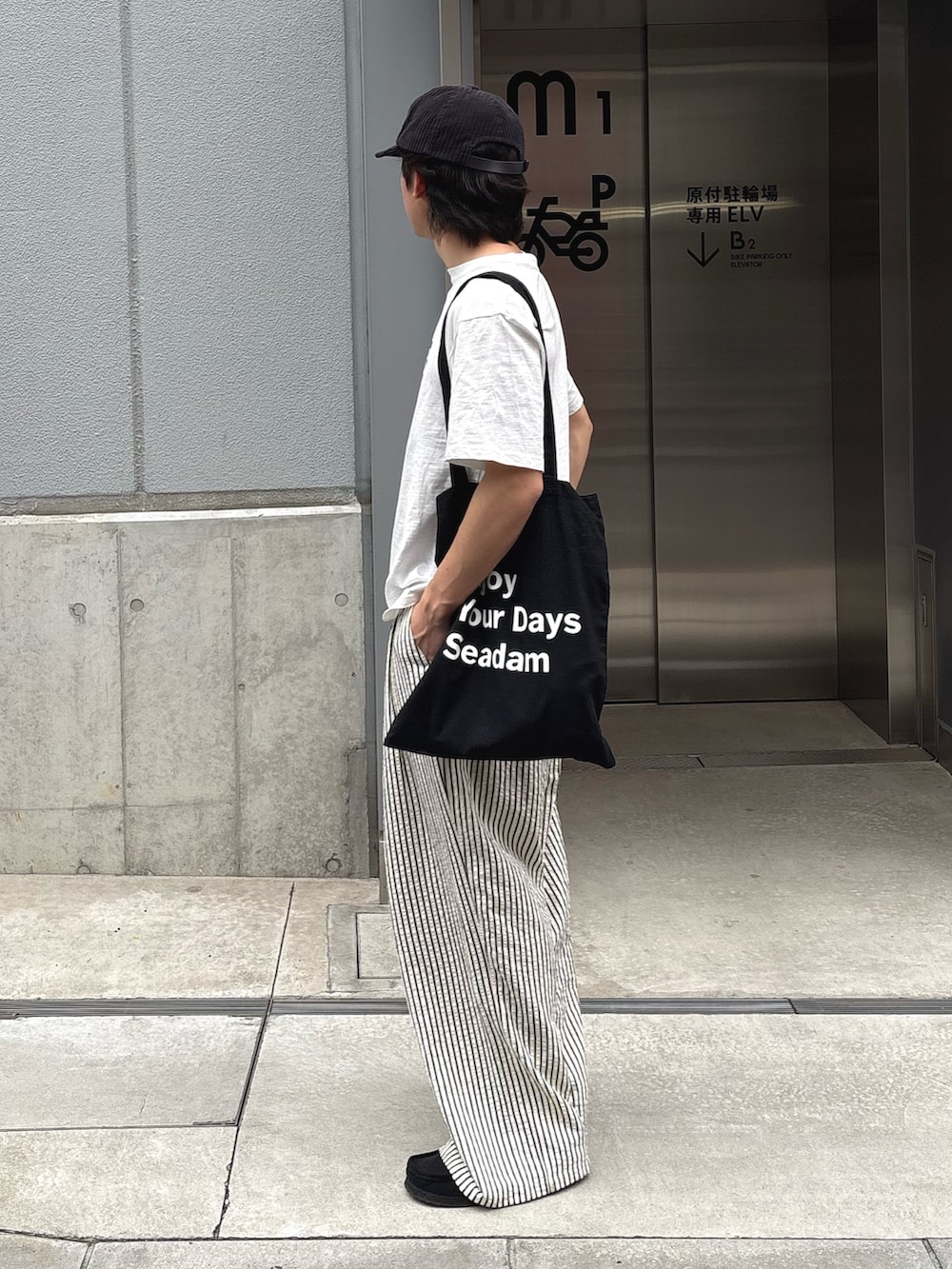 ホワイト系のTシャツ/カットソー、ブラック系のトートバッグ、ホワイト系のその他パンツを着用したメンズの春コーディネートの2枚目の写真