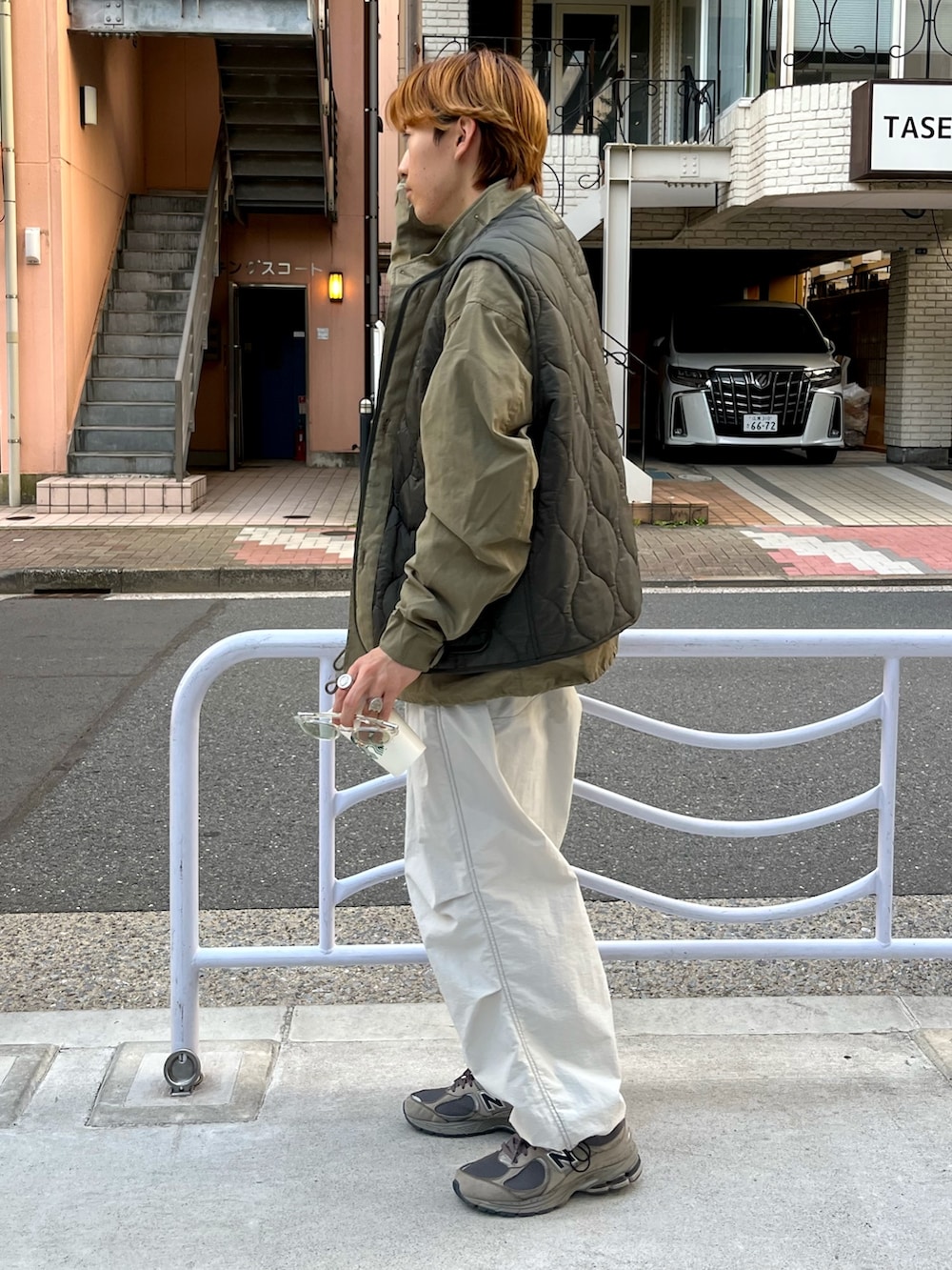 グレー系のスニーカー、グレー系のカーゴパンツ、グリーン系のモッズコートを着用したメンズの秋コーディネートの2枚目の写真