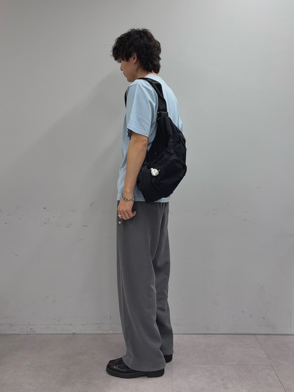ブルー系のTシャツ/カットソー、ブラック系のバックパック/リュック、グレー系のスウェットパンツを着用したメンズの夏コーディネートの2枚目の写真