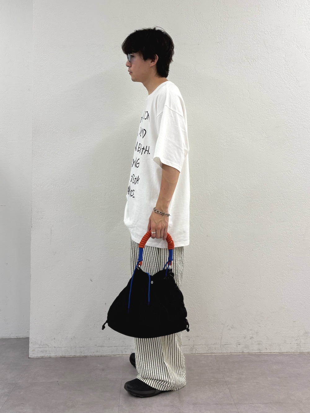 ホワイト系のTシャツ/カットソー、ホワイト系のその他パンツ、ブラック系のトートバッグを着用したメンズの夏コーディネートの2枚目の写真