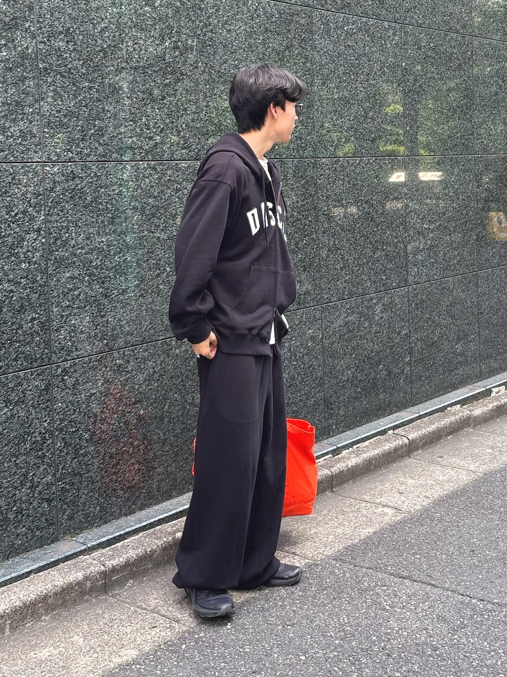 ブラック系のパーカー、ホワイト系のTシャツ/カットソー、ブラック系のスウェットパンツを着用したメンズの秋コーディネートの3枚目の写真