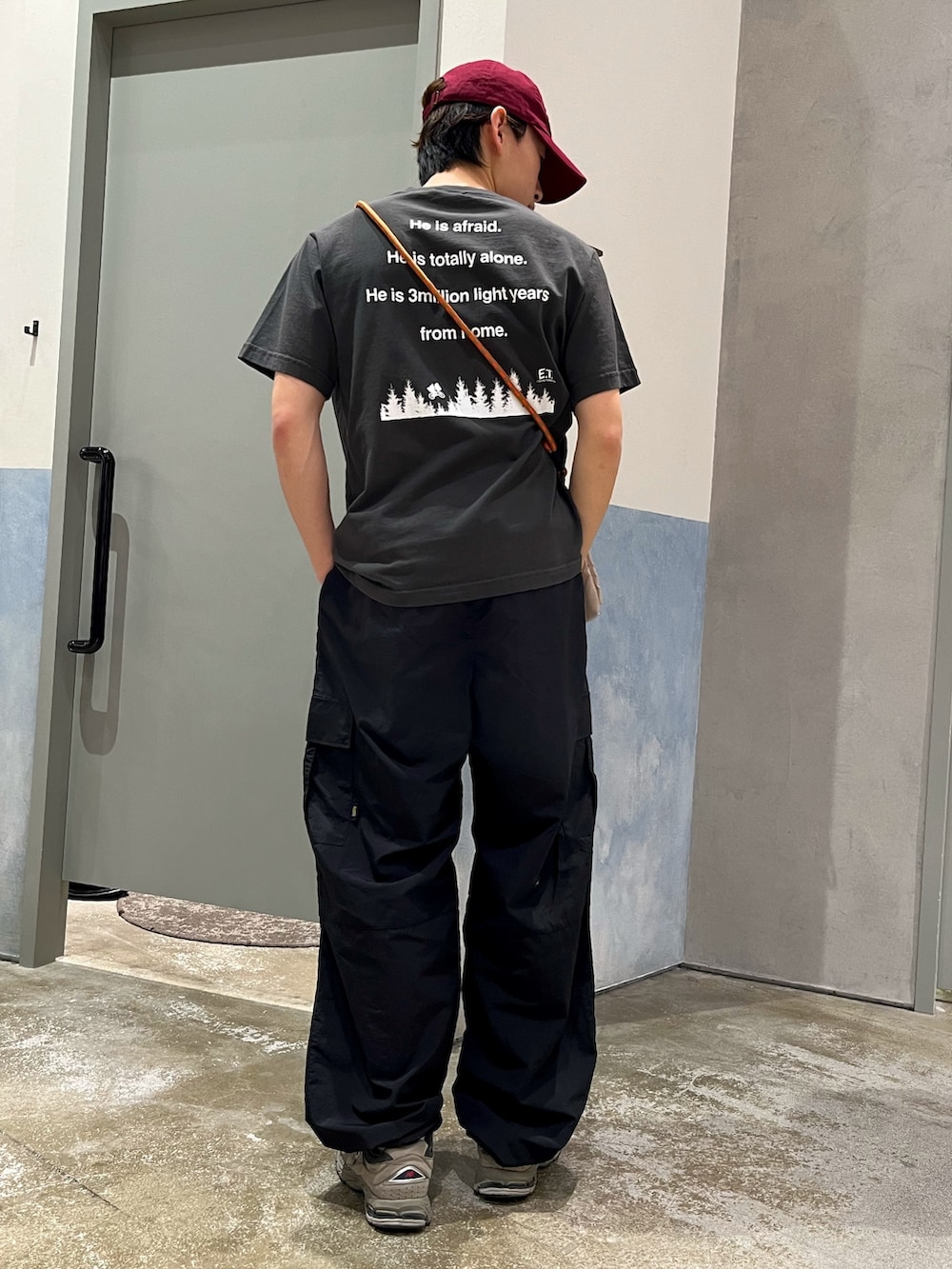 ブラック系のカーゴパンツ、グレー系のスニーカー、ブラック系のTシャツ/カットソーを着用したメンズの夏コーディネートの2枚目の写真