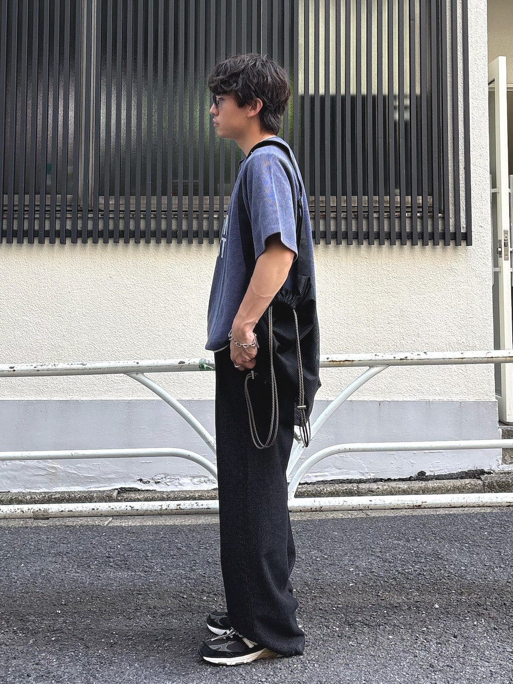 ブルー系のTシャツ/カットソー、ブラック系のトートバッグ、ブラック系のスラックスを着用したメンズの夏コーディネートの2枚目の写真
