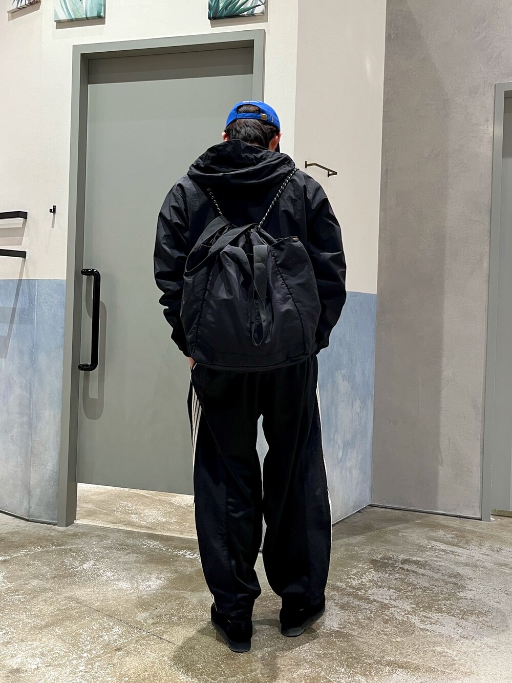 ブラック系のスニーカー、ブラック系のスウェットパンツ、ブラック系のバックパック/リュックを着用したメンズの春コーディネートの3枚目の写真