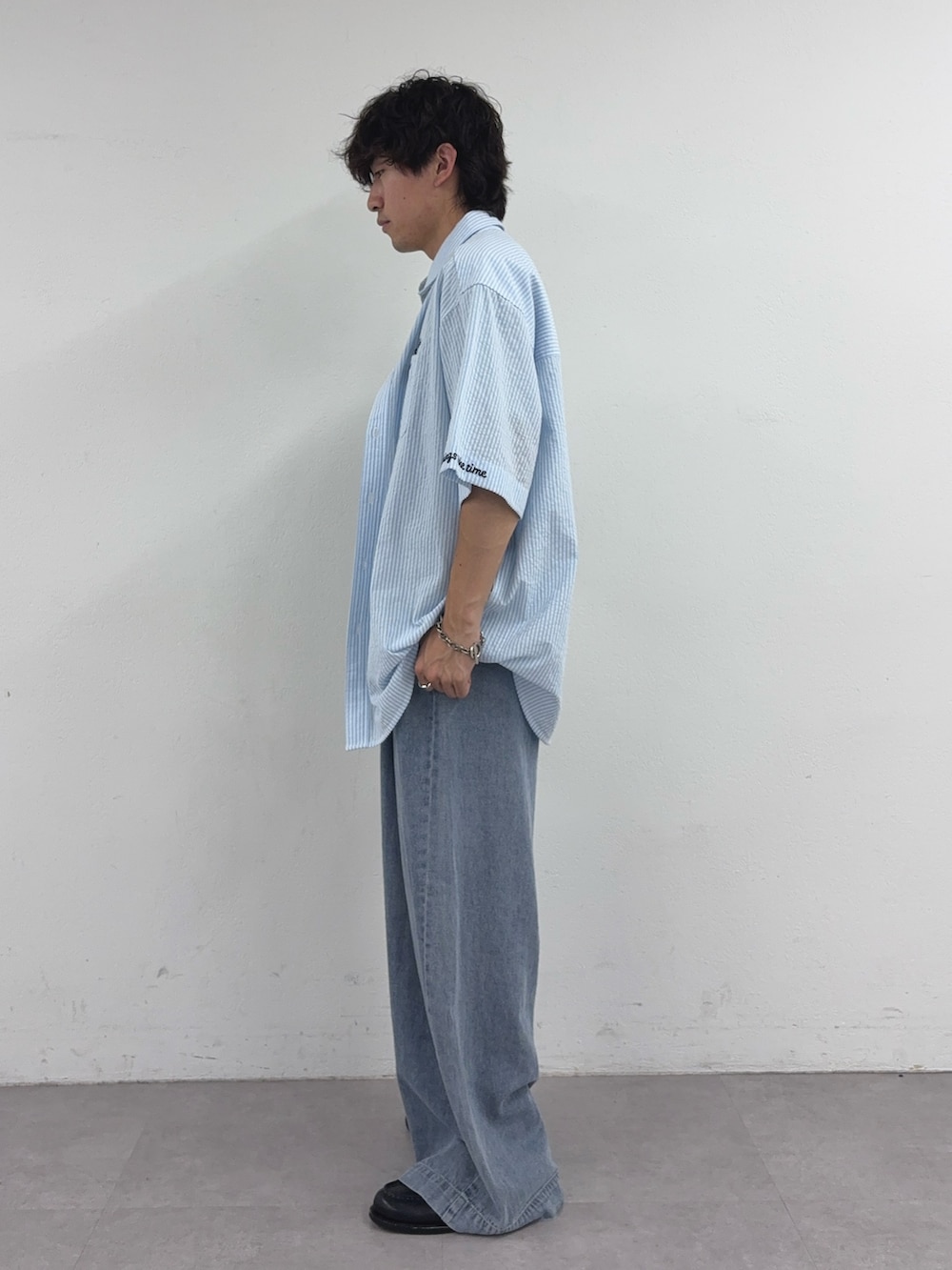 ブルー系のシャツ/ブラウス、グレー系のTシャツ/カットソー、ブルー系のデニムパンツを着用したメンズの春コーディネートの2枚目の写真
