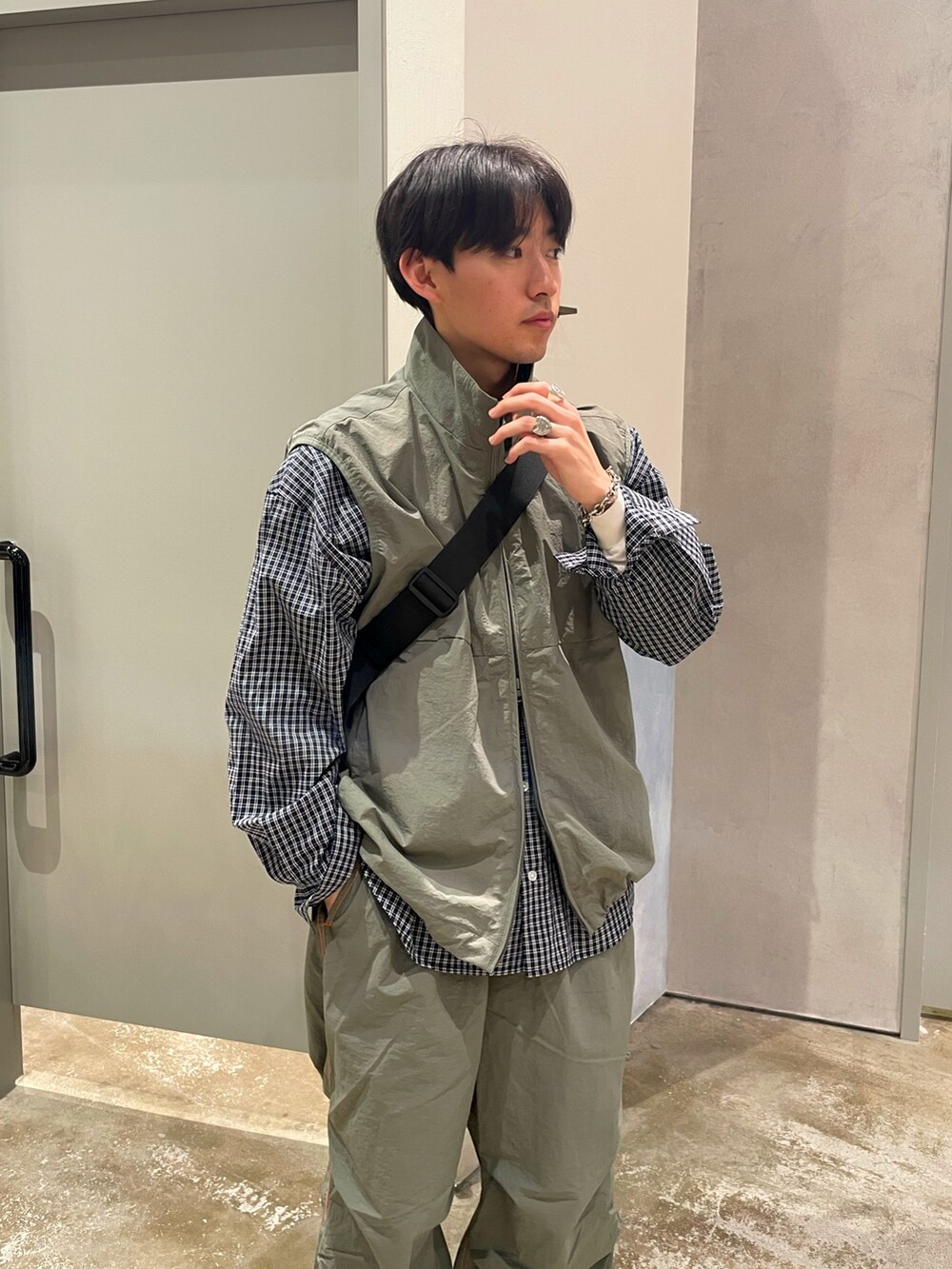 ブラック系のスニーカー、グリーン系のカーゴパンツ、ブルー系のシャツ/ブラウスを着用したメンズの春コーディネートの3枚目の写真