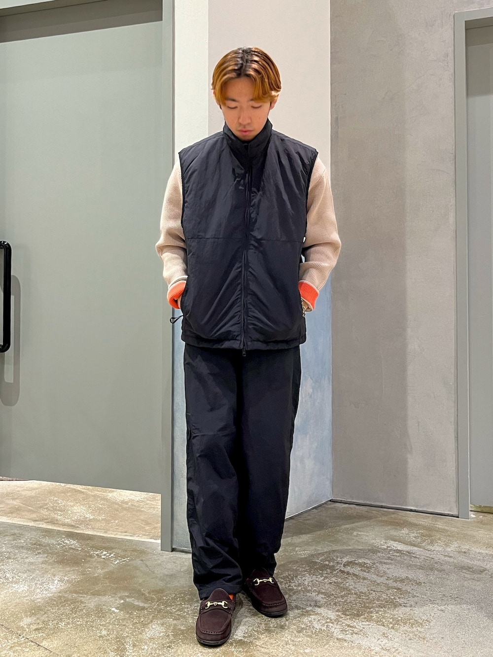 ブラック系のその他パンツ、ブラック系のベスト、ベージュ系のニット/セーターを着用したメンズの秋コーディネートの2枚目の写真