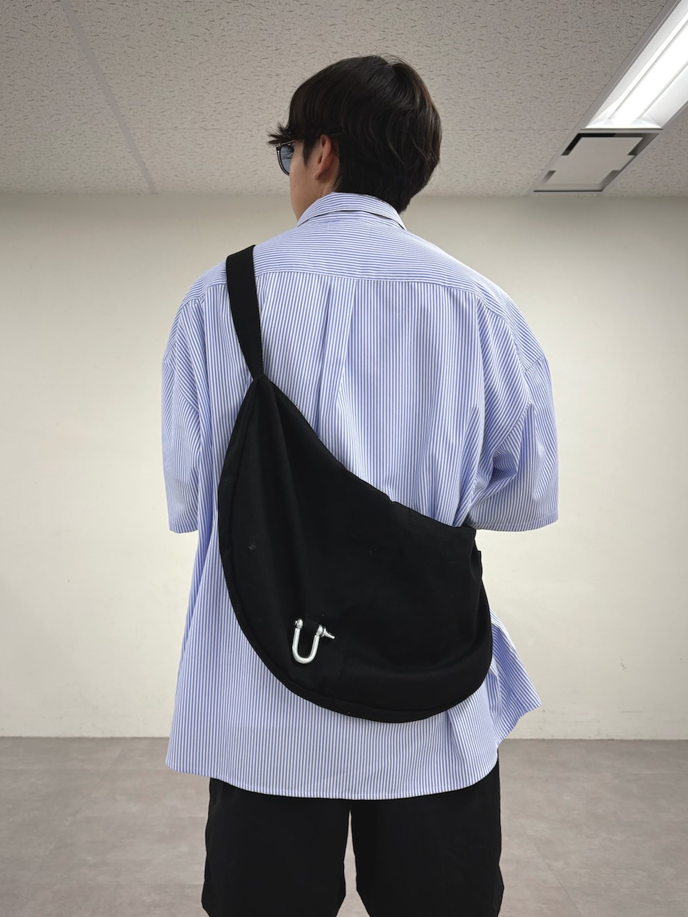 ブルー系のシャツ/ブラウス、ブラック系のショルダーバッグ、ブラック系のその他パンツを着用したメンズの夏コーディネートの3枚目の写真