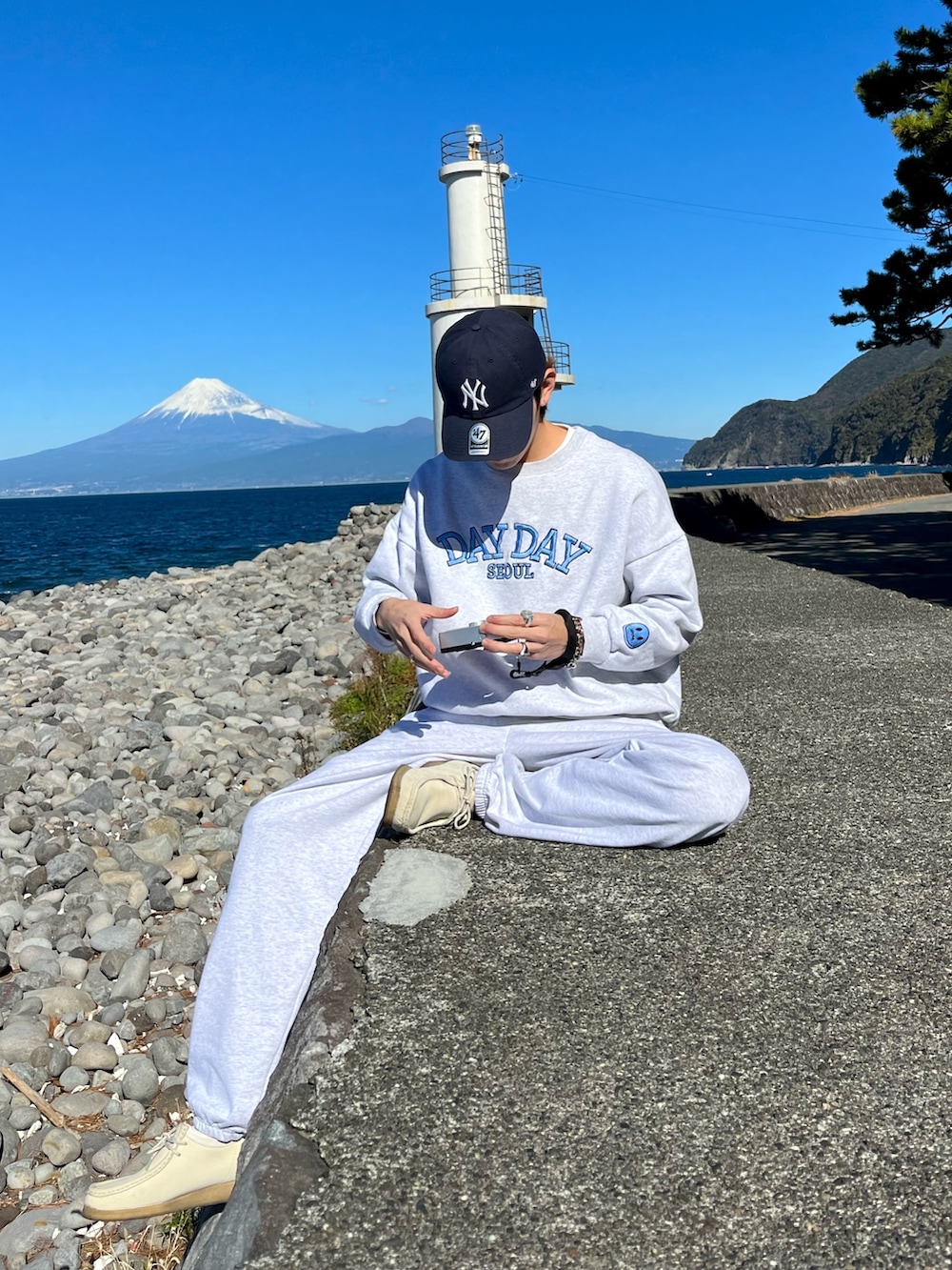 ホワイト系のスニーカー、グレー系のスウェットパンツ、ホワイト系のTシャツ/カットソーを着用したメンズの秋コーディネートの2枚目の写真