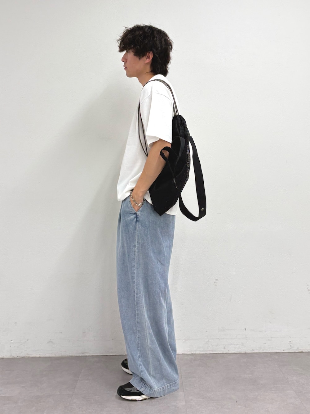 ホワイト系のTシャツ/カットソー、ブラック系のトートバッグ、ブルー系のデニムパンツを着用したメンズの夏コーディネートの2枚目の写真
