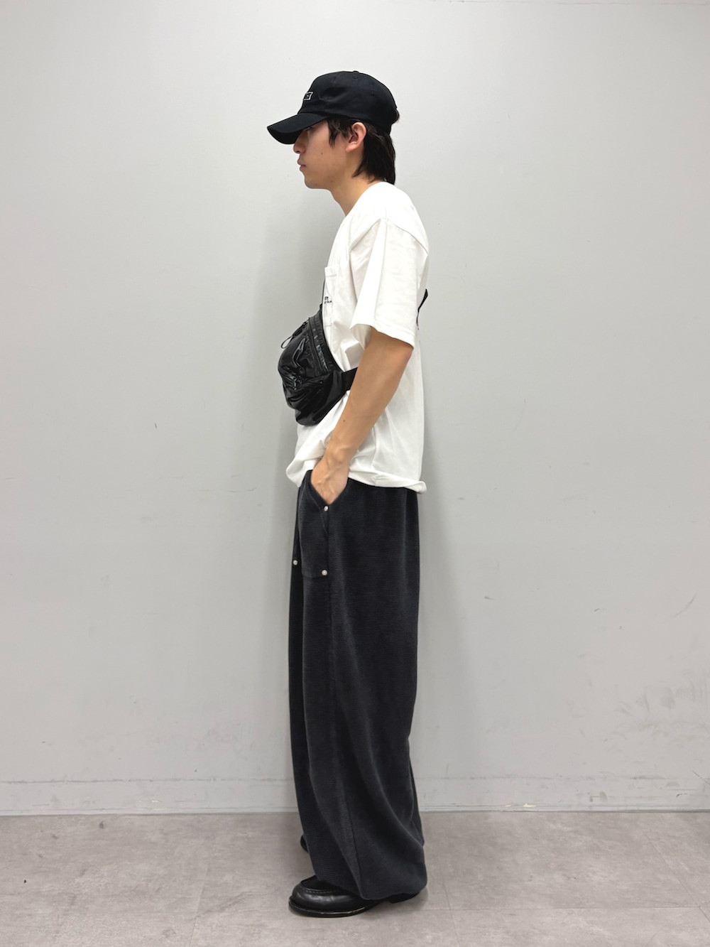 ホワイト系のTシャツ/カットソー、ブラック系のボディバッグ/ウエストポーチ、ブラック系のスウェットパンツを着用したメンズの春コーディネートの2枚目の写真