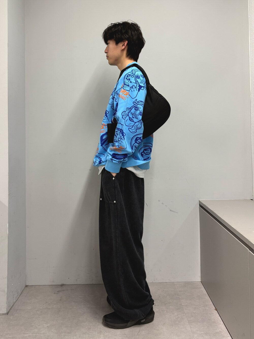 グリーン系のTシャツ/カットソー、ブラック系のショルダーバッグ、ブラック系のスウェットパンツを着用したメンズの春コーディネートの2枚目の写真