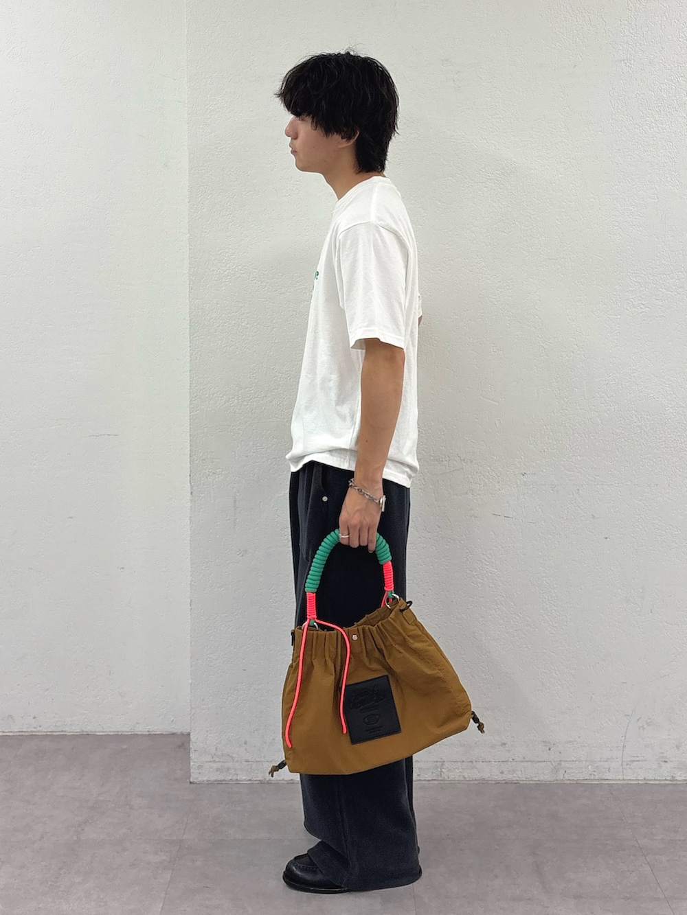 ホワイト系のTシャツ/カットソー、ブラック系のスウェットパンツ、イエロー系のトートバッグを着用したメンズの夏コーディネートの2枚目の写真