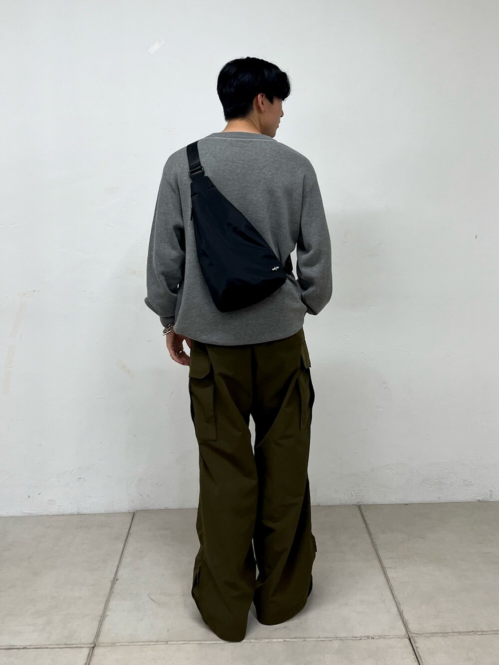 グリーン系のカーゴパンツ、ブラック系のスニーカー、グレー系のニット/セーターを着用したメンズの秋コーディネートの3枚目の写真