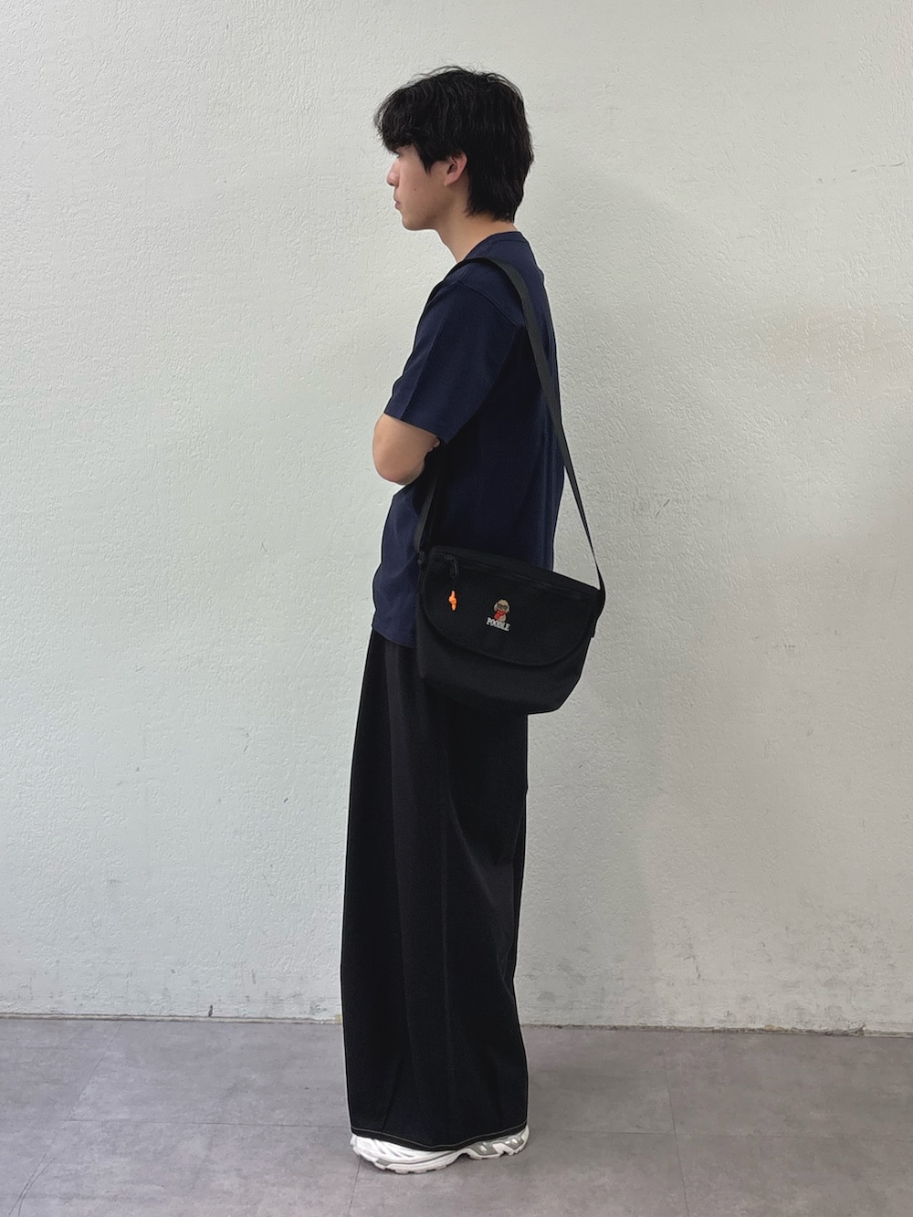 ブルー系のTシャツ/カットソー、ブラック系のチノパンツ、ブラック系のショルダーバッグを着用したメンズの春コーディネートの2枚目の写真