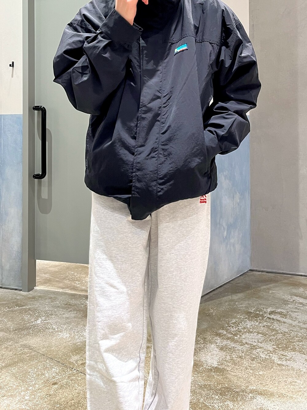 ホワイト系のスニーカー、グレー系のスウェットパンツ、ブラック系のナイロンジャケットを着用したメンズの秋コーディネートの3枚目の写真