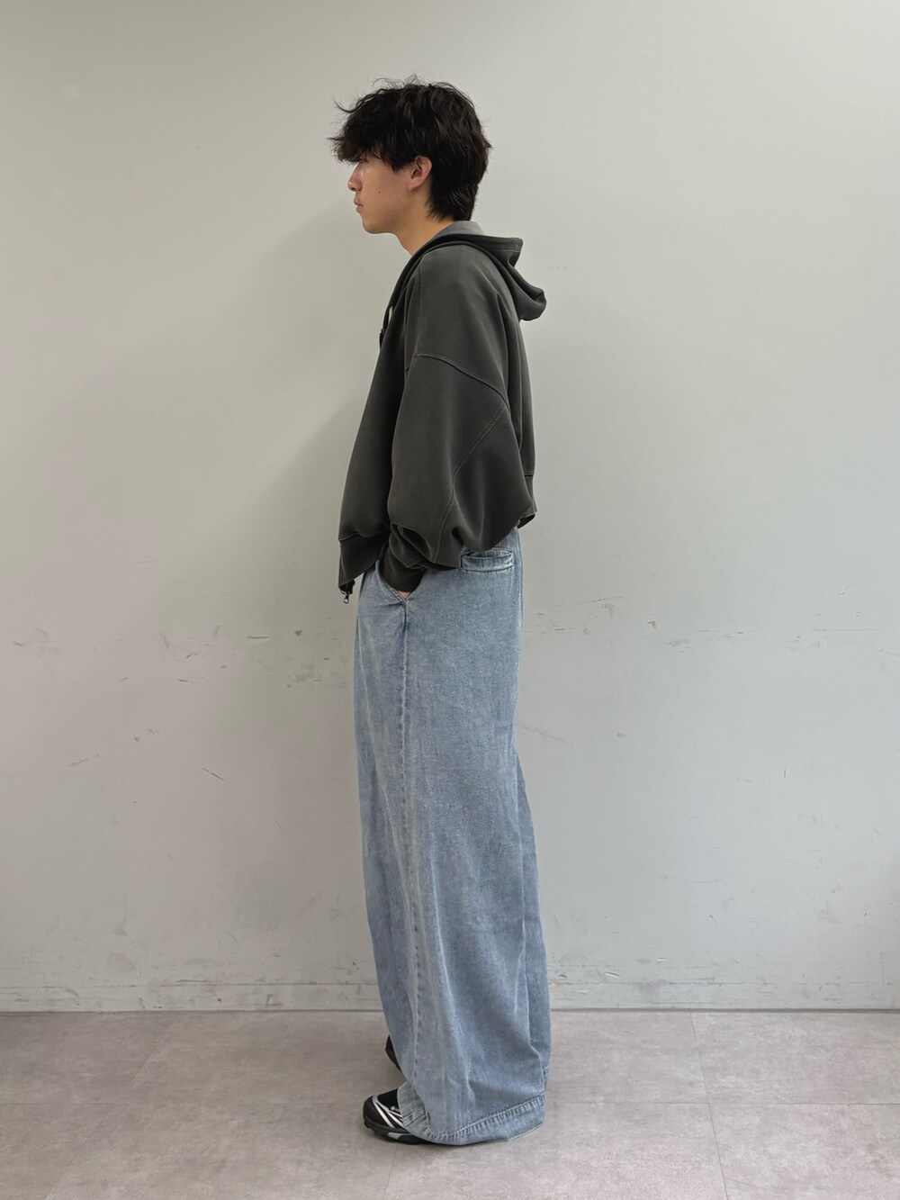 グレー系のパーカー、ホワイト系のTシャツ/カットソー、ブルー系のデニムパンツを着用したメンズの秋コーディネートの2枚目の写真