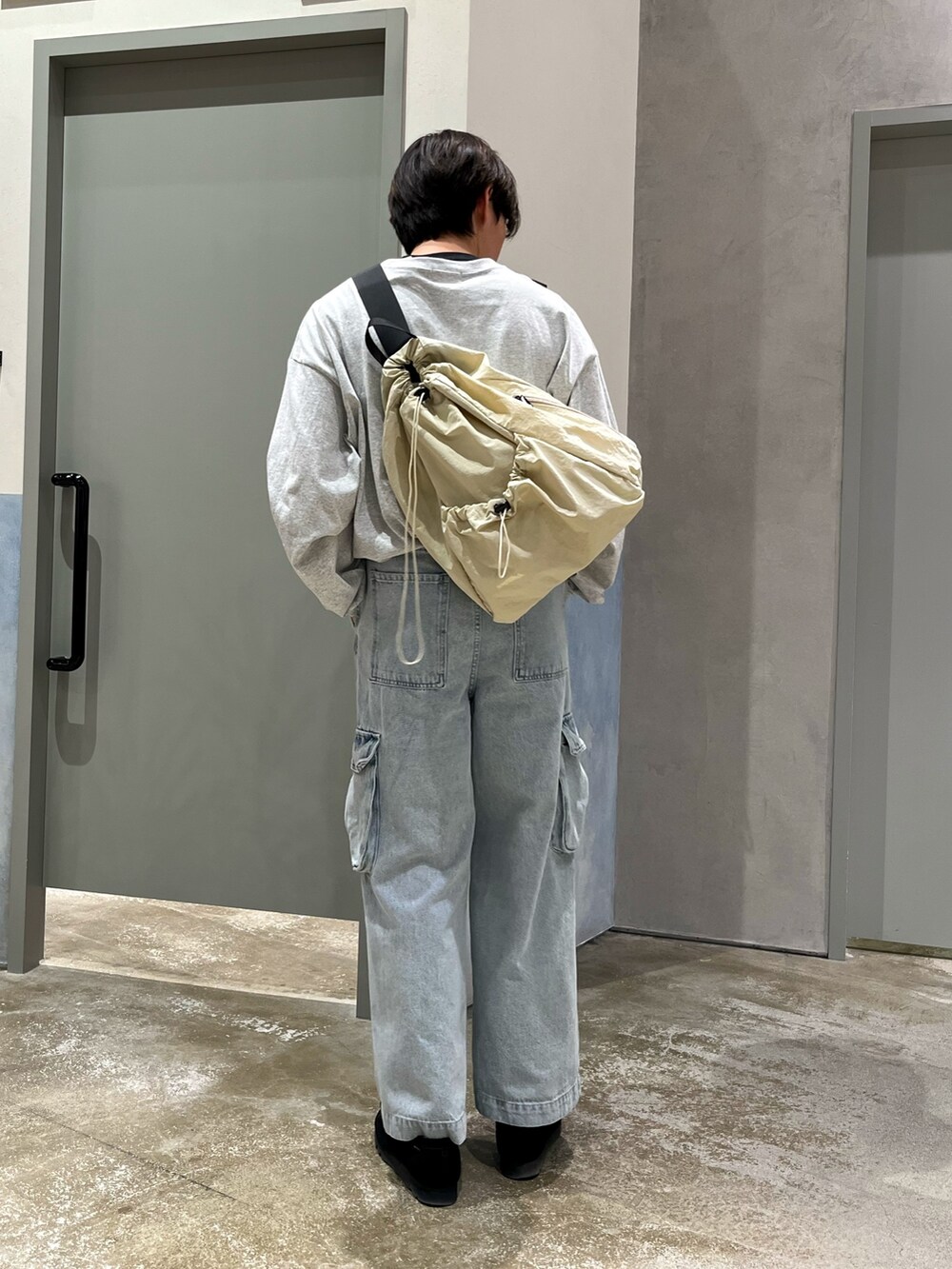 ブラック系のスニーカー、ブルー系のカーゴパンツ、グレー系のTシャツ/カットソーを着用したメンズの春コーディネートの2枚目の写真