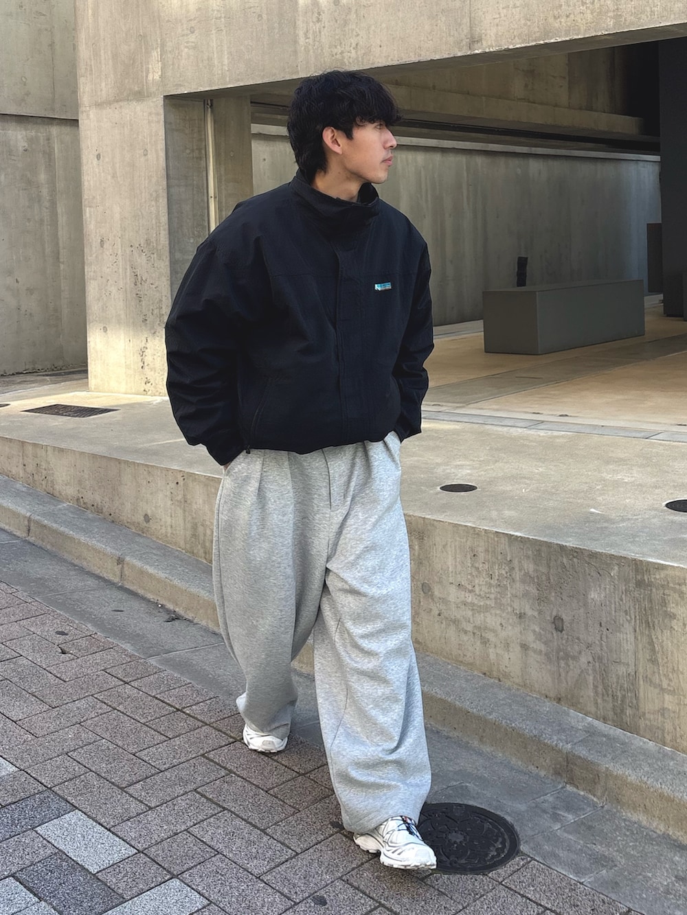 ブラック系のナイロンジャケット、グレー系のその他パンツを着用したメンズの冬コーディネートの2枚目の写真