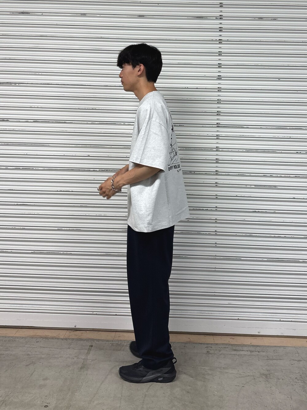 グレー系のTシャツ/カットソー、ブルー系のスラックスを着用したメンズの春コーディネートの2枚目の写真