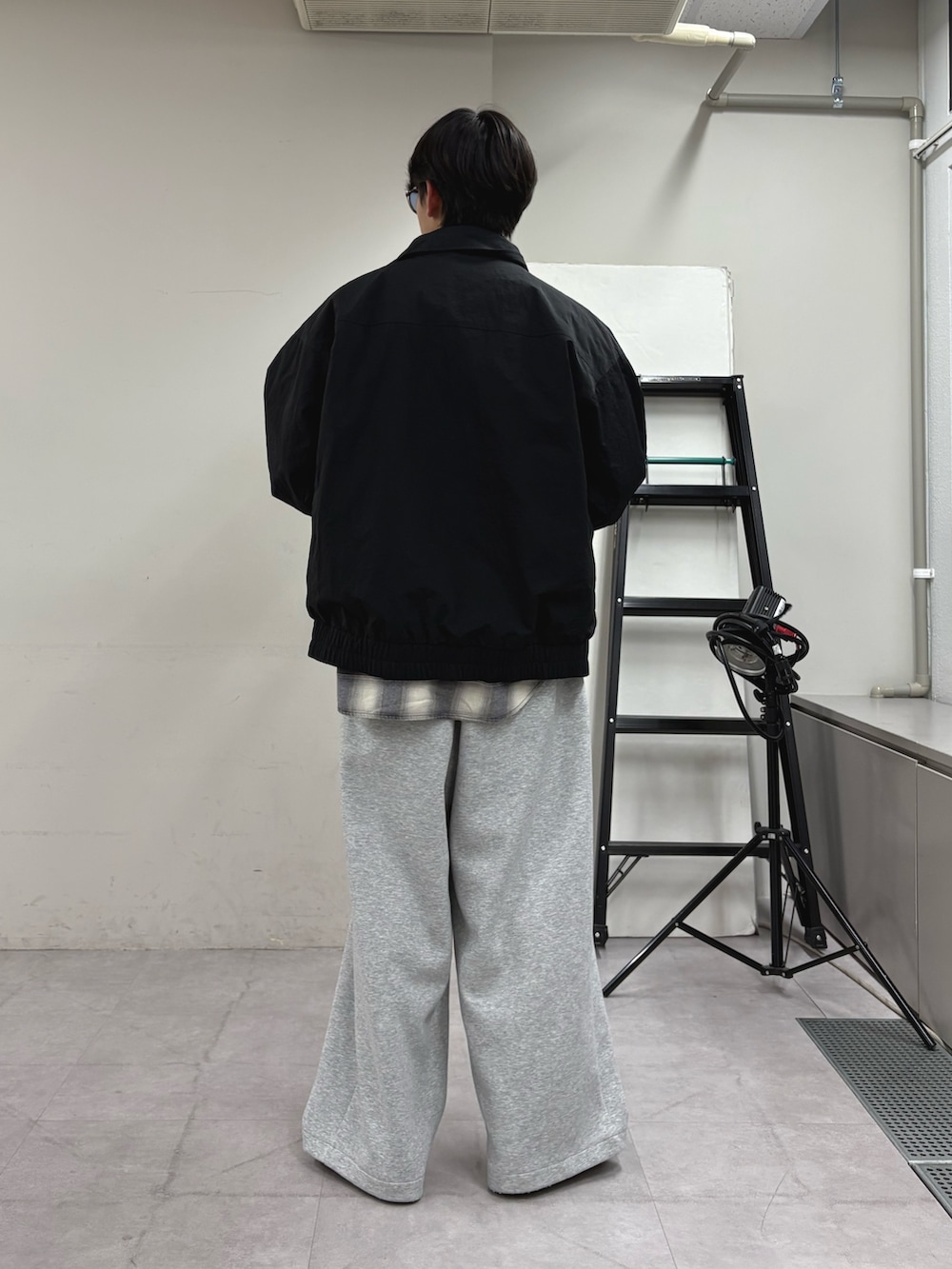 ブラック系のナイロンジャケット、ホワイト系のシャツ/ブラウス、グレー系のその他パンツを着用したメンズの秋コーディネートの3枚目の写真