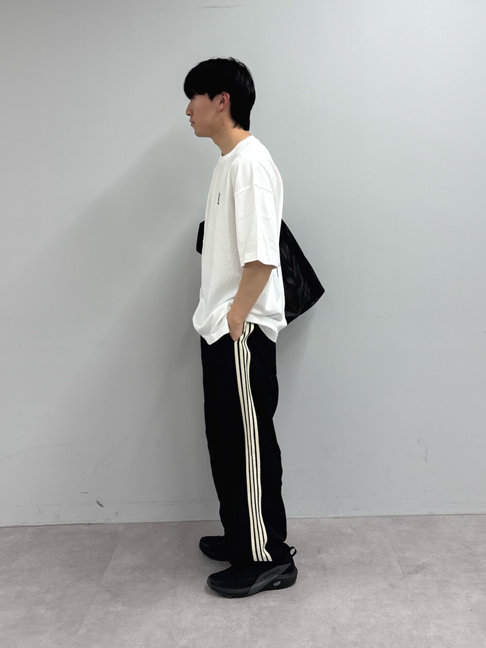 ホワイト系のTシャツ/カットソー、ブラック系のトートバッグ、ブラック系のスウェットパンツを着用したメンズの春コーディネートの3枚目の写真