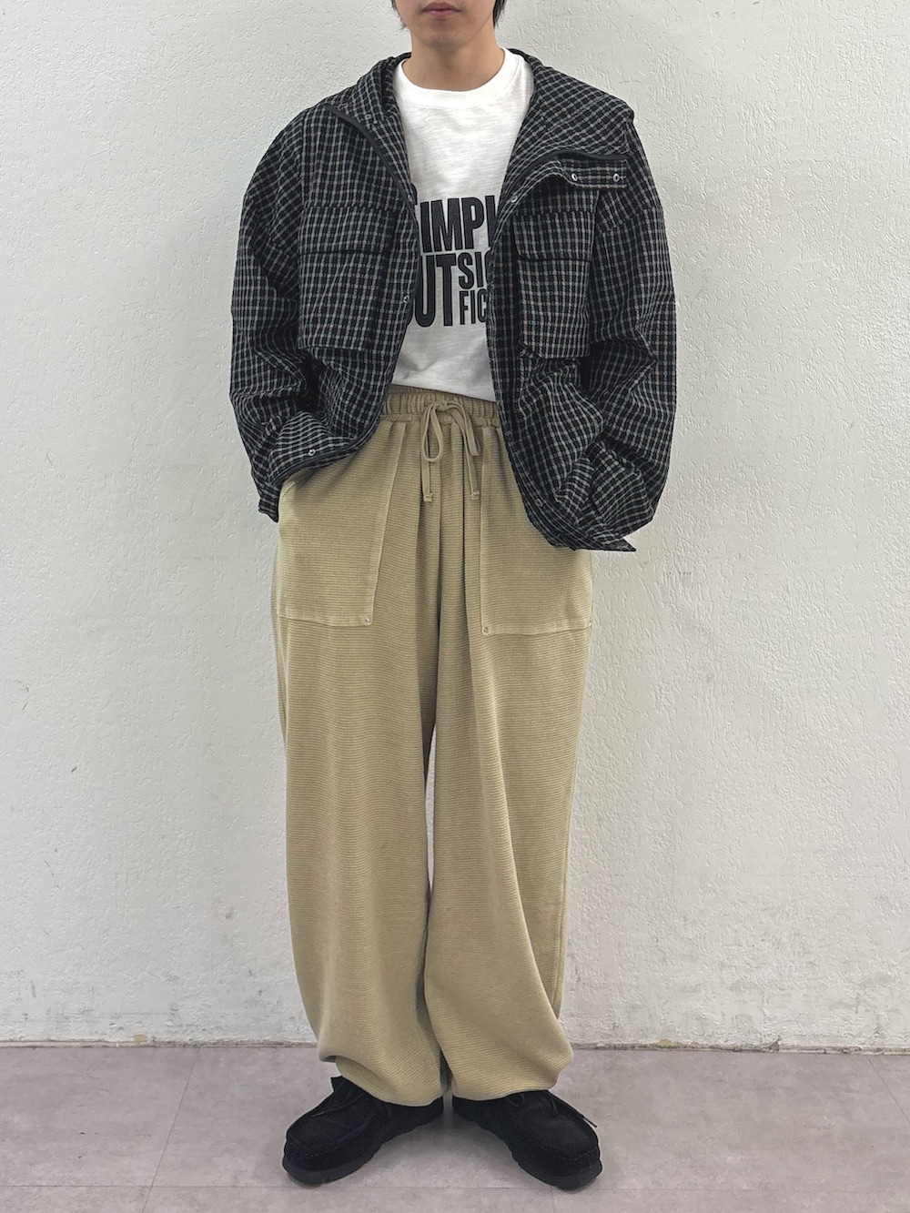 ブラック系のパーカー、ホワイト系のTシャツ/カットソー、ベージュ系のスウェットパンツを着用したメンズの春コーディネートの2枚目の写真