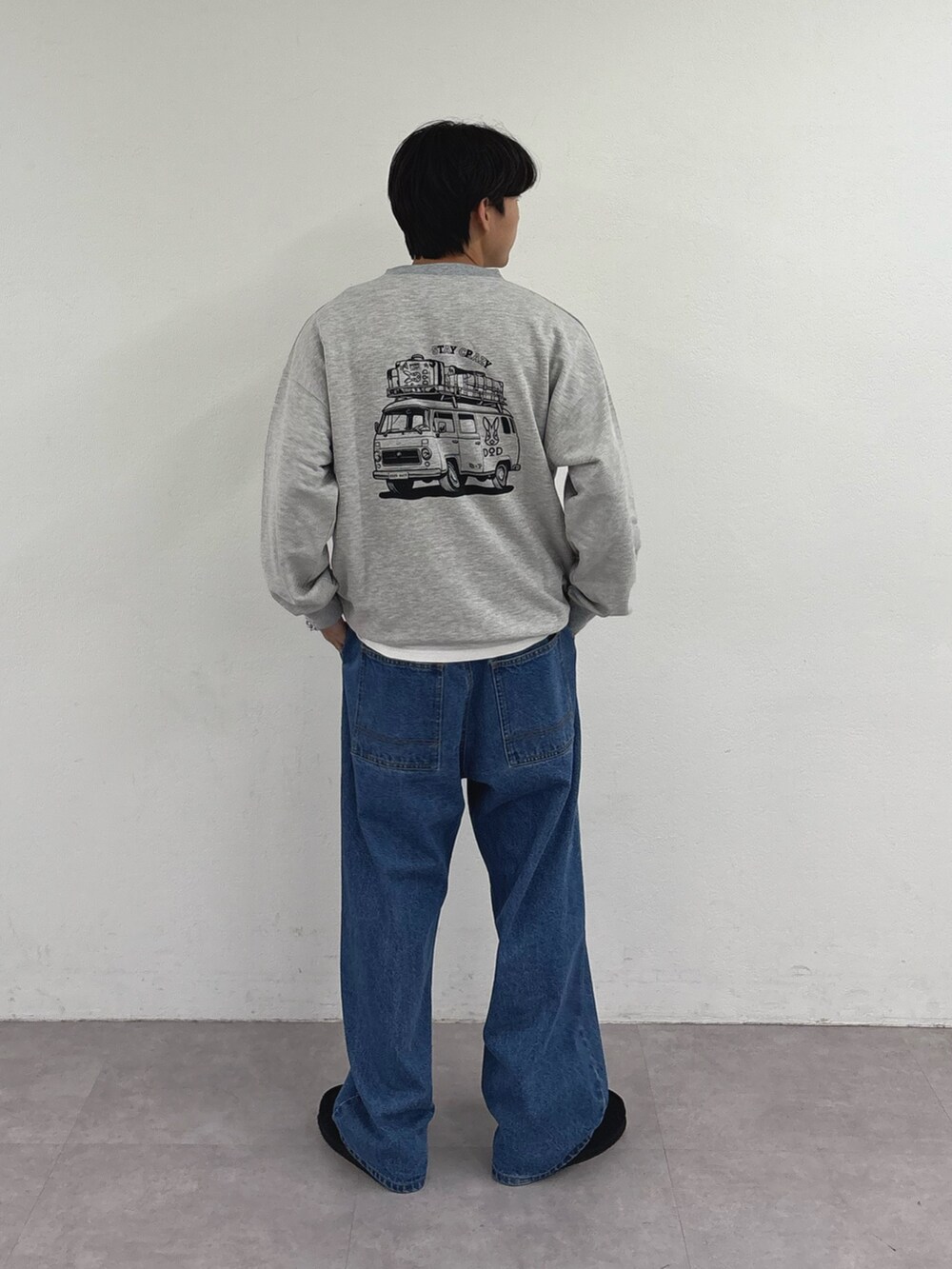 グレー系のスウェット、ブルー系のデニムパンツを着用したメンズの秋コーディネートの2枚目の写真