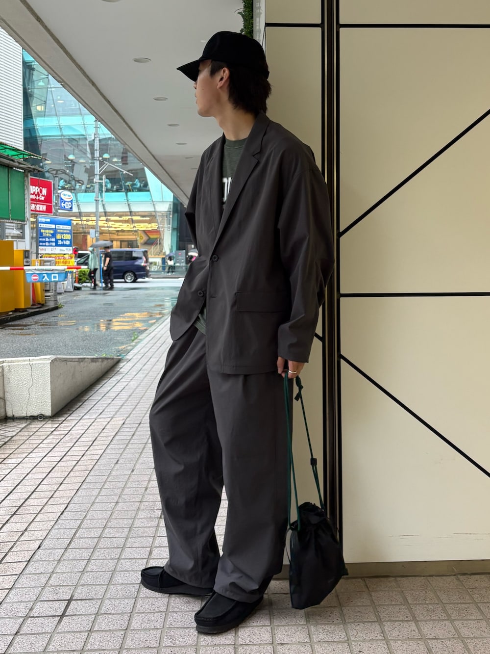 グレー系のテーラードジャケット、グリーン系のTシャツ/カットソー、グレー系のスラックスを着用したメンズの夏コーディネートの2枚目の写真