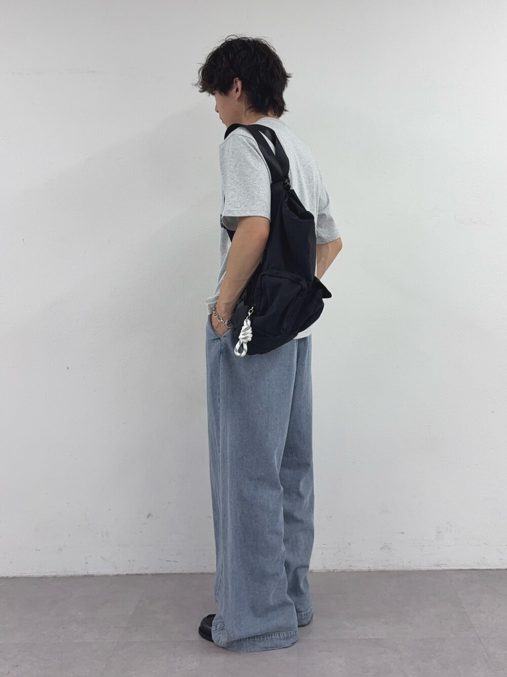 グレー系のTシャツ/カットソー、ブラック系のバックパック/リュック、ブルー系のデニムパンツを着用したメンズの夏コーディネートの2枚目の写真