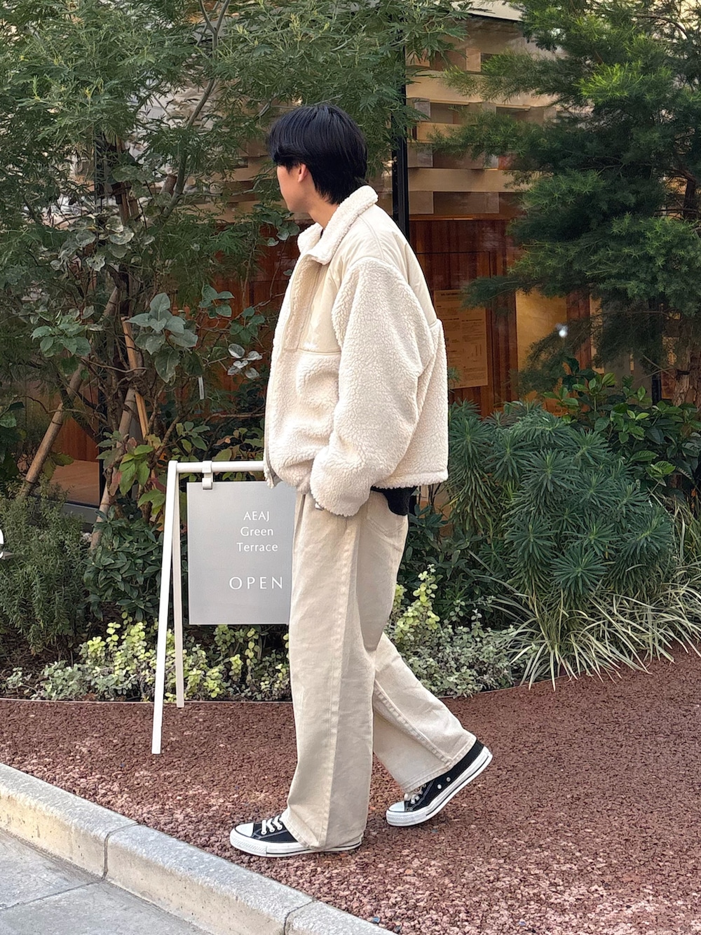 ブラック系のスウェット、ホワイト系のブルゾン、グレー系のデニムパンツを着用したメンズの冬コーディネートの2枚目の写真