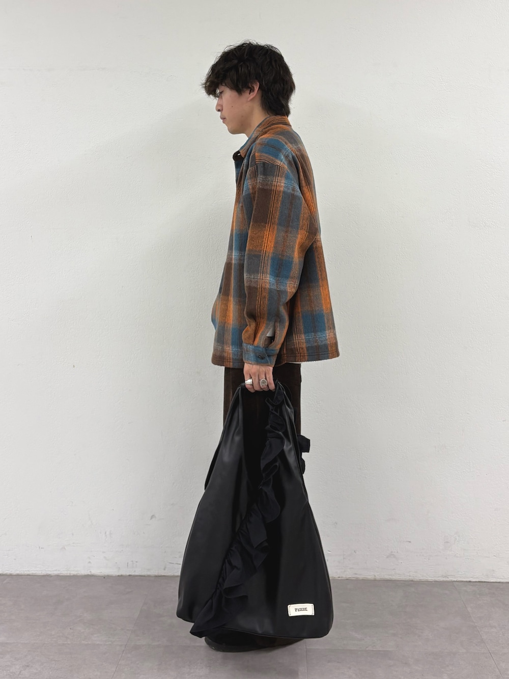 オレンジ系のシャツ/ブラウス、ブラウン系のその他パンツ、ブラック系のトートバッグを着用したメンズの秋コーディネートの2枚目の写真