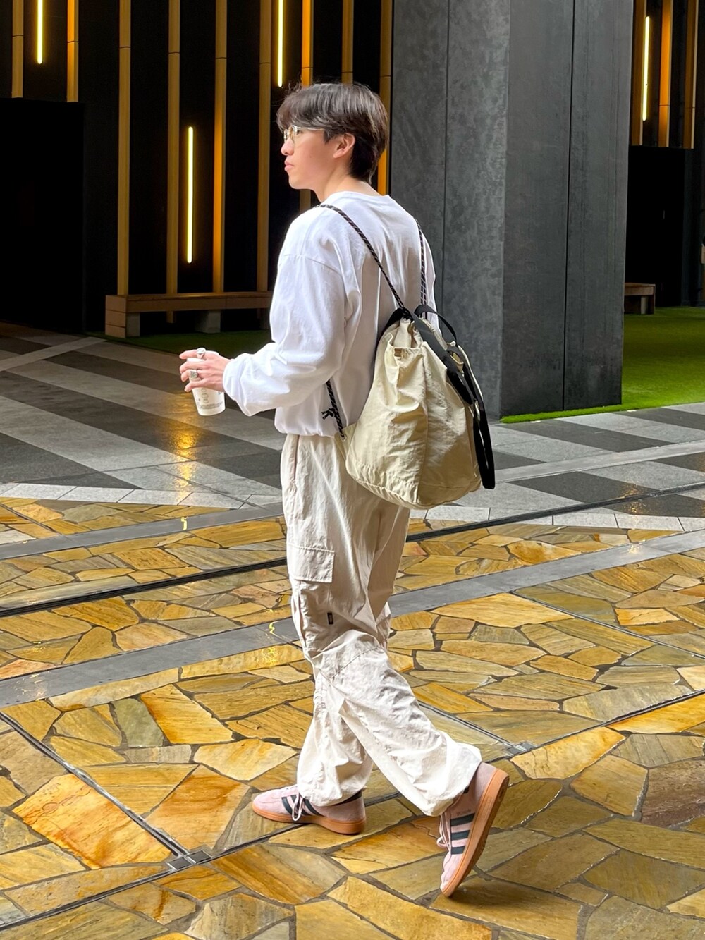 ピンク系のスニーカー、ホワイト系のカーゴパンツ、ホワイト系のTシャツ/カットソーを着用したメンズの春コーディネートの2枚目の写真